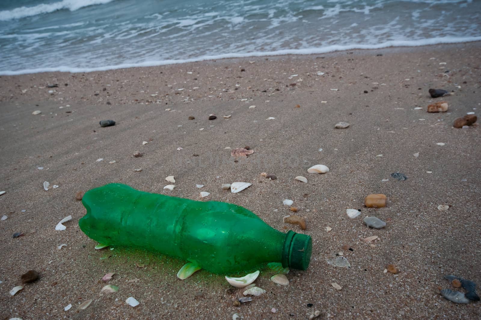 green plastic bottle garbage on the beach