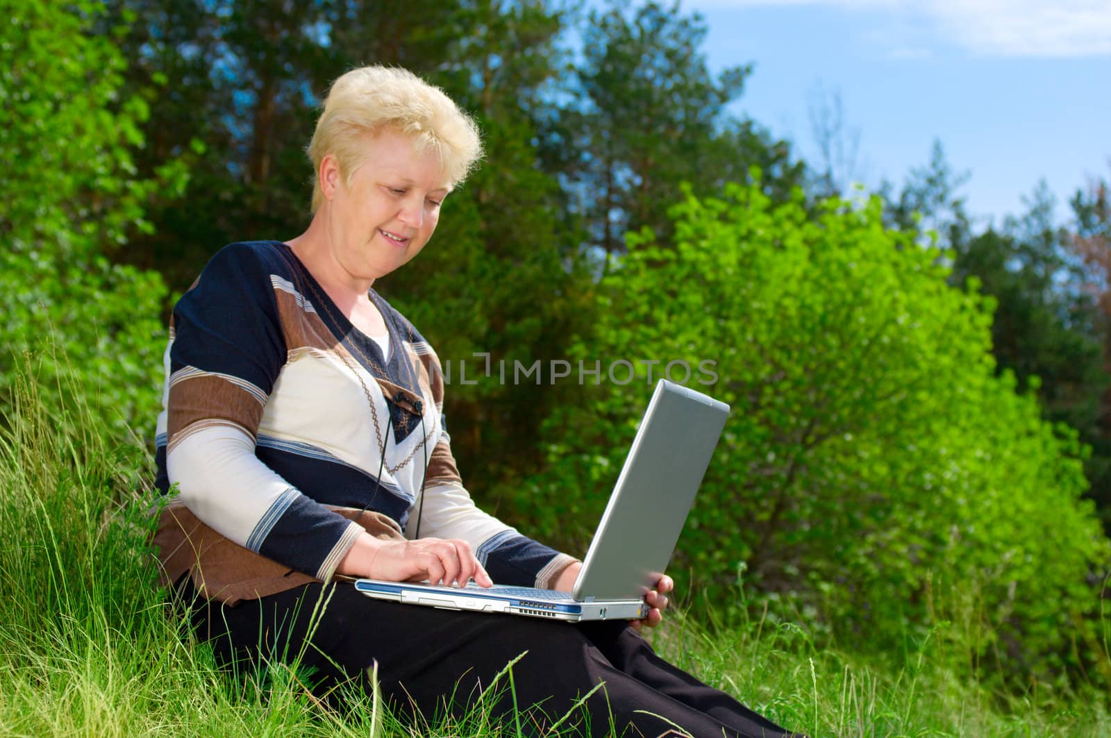 Senior woman with parasol in forest