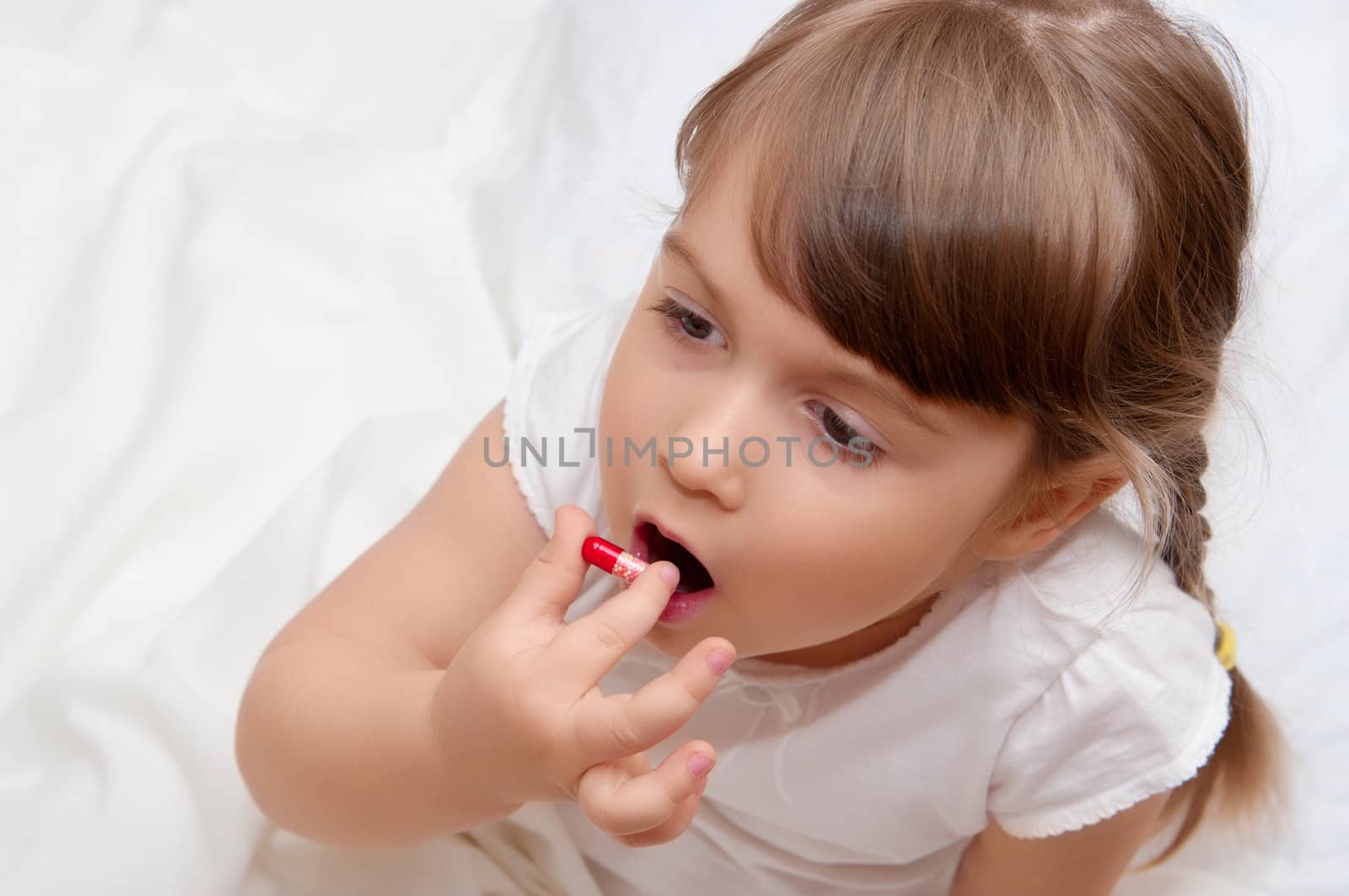 Little girl with red pill