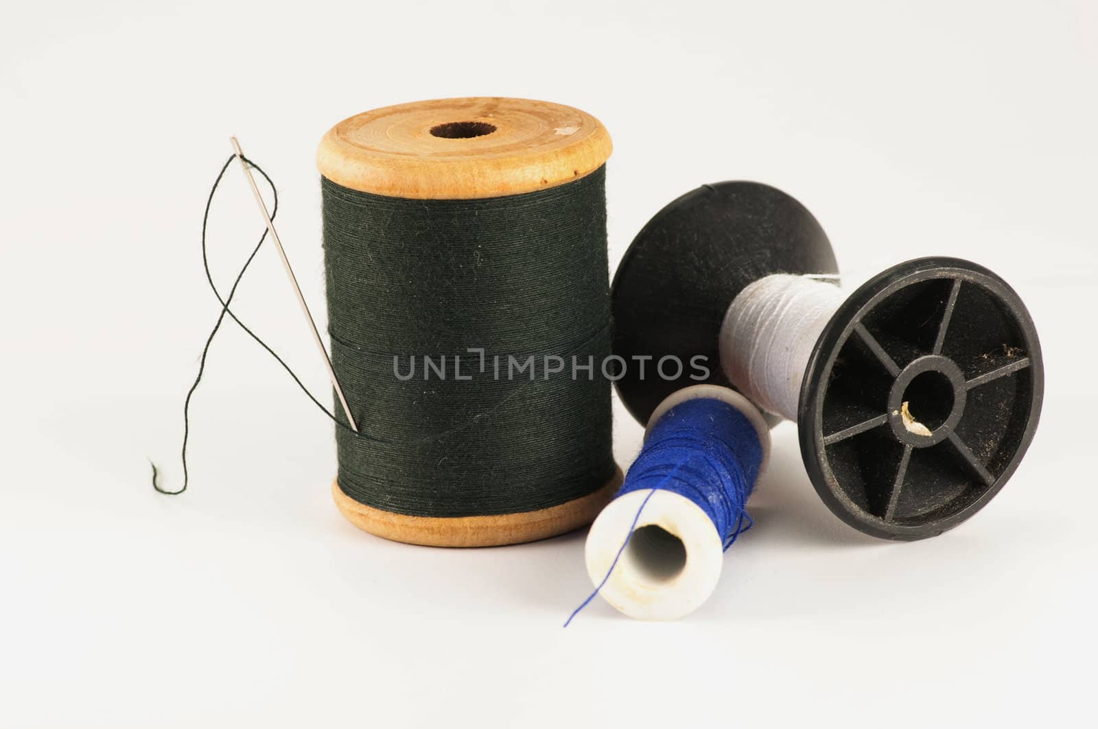 Spool of thread with needle  on white background