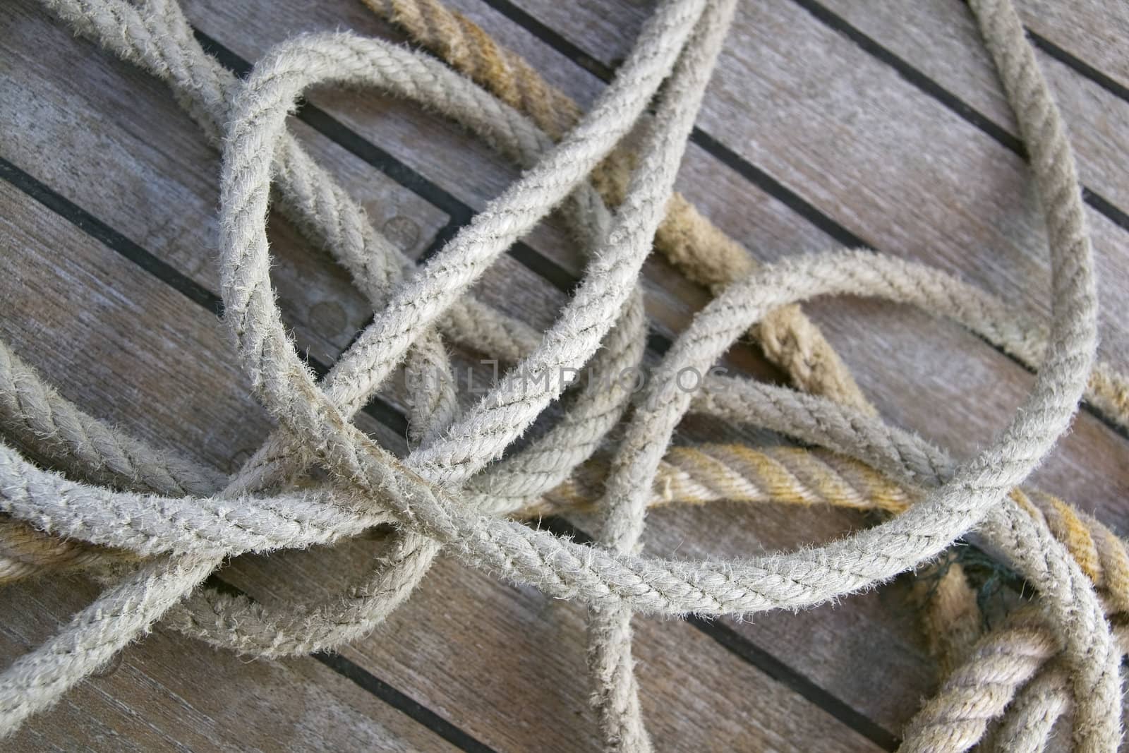 Close-up of thick textile ropes laying on a ship's deck