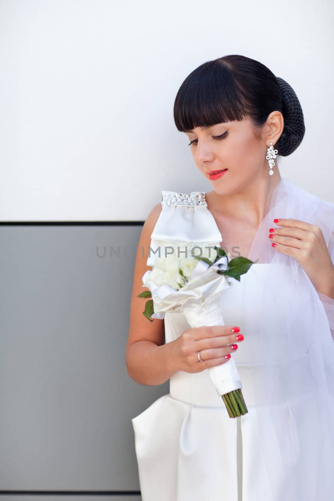 bride with white roses near the wall