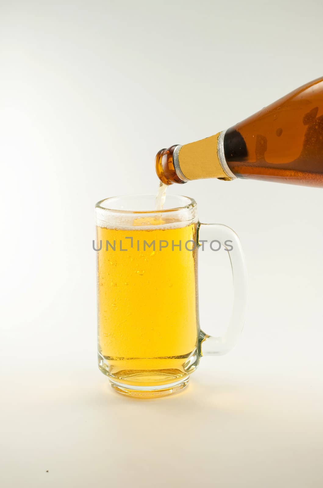 bottle and glass of beer on white background
