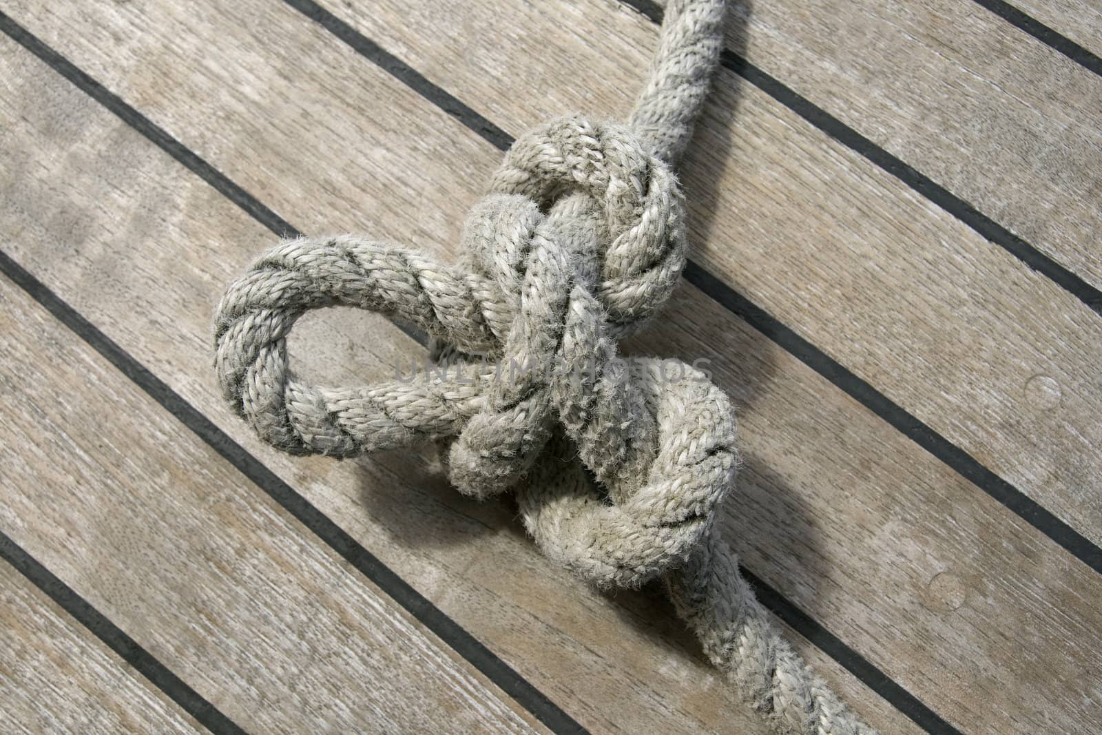 Butterfly knot tied on a thick rope laying on a ship deck
