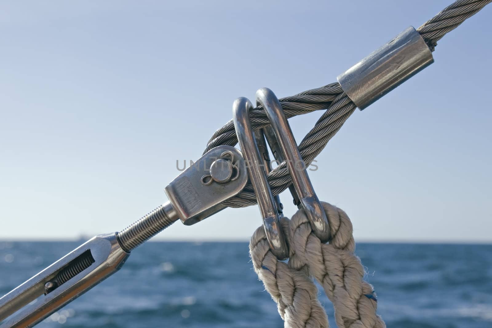 Detail of sailboat rigging against water and sky