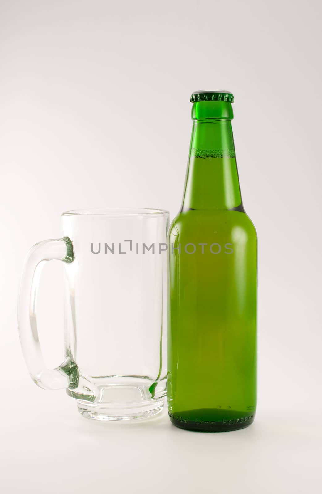 bottle and glass of beer on white background