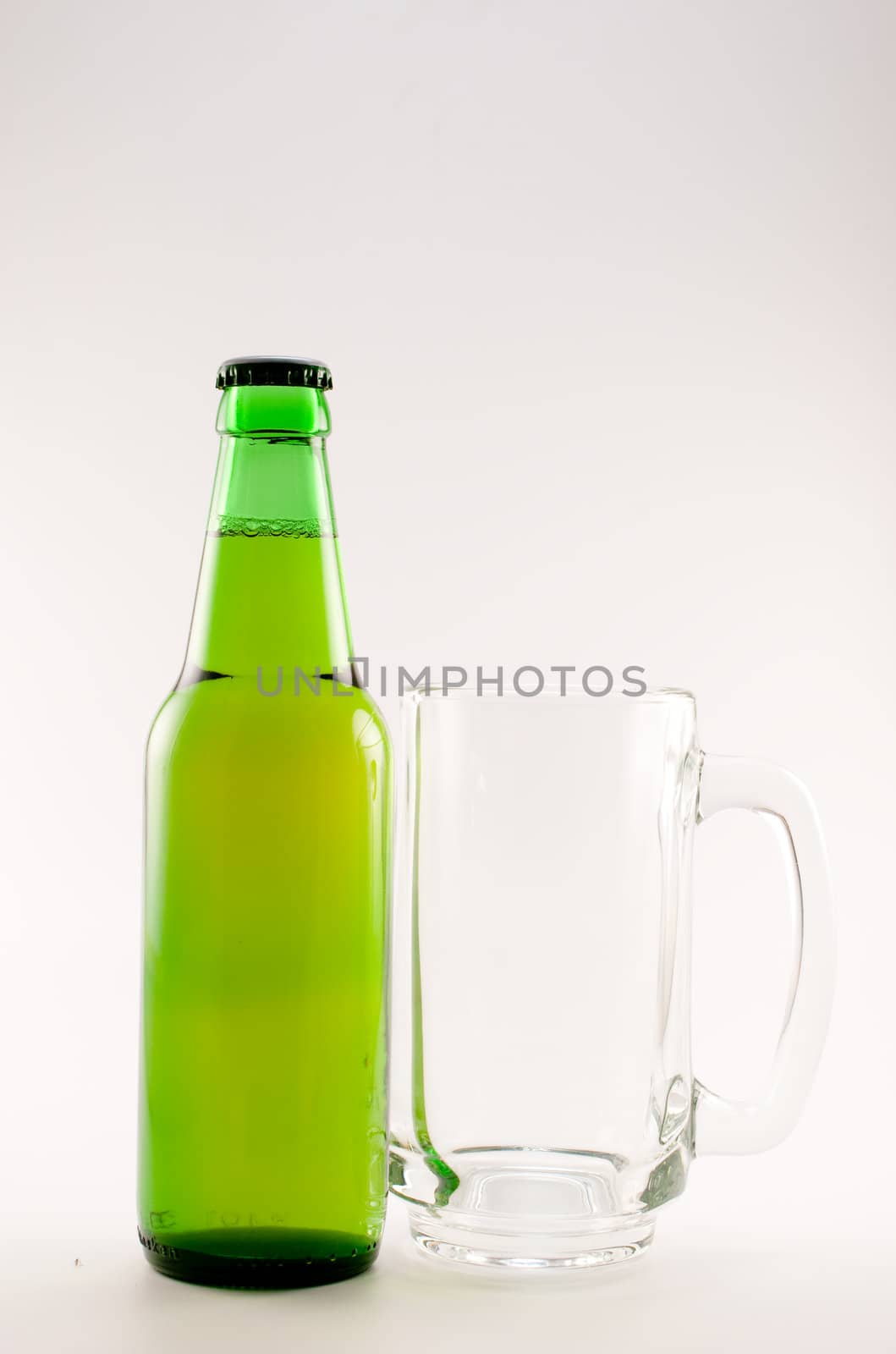 bottle and glass of beer on white background