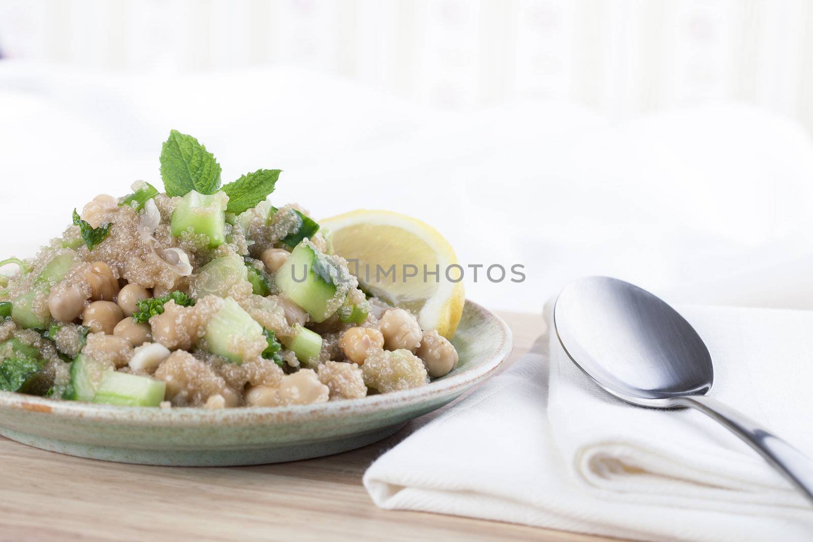 Healthy amaranth grain prepared tabbouleh style with chickpeas, and a lemon wedge