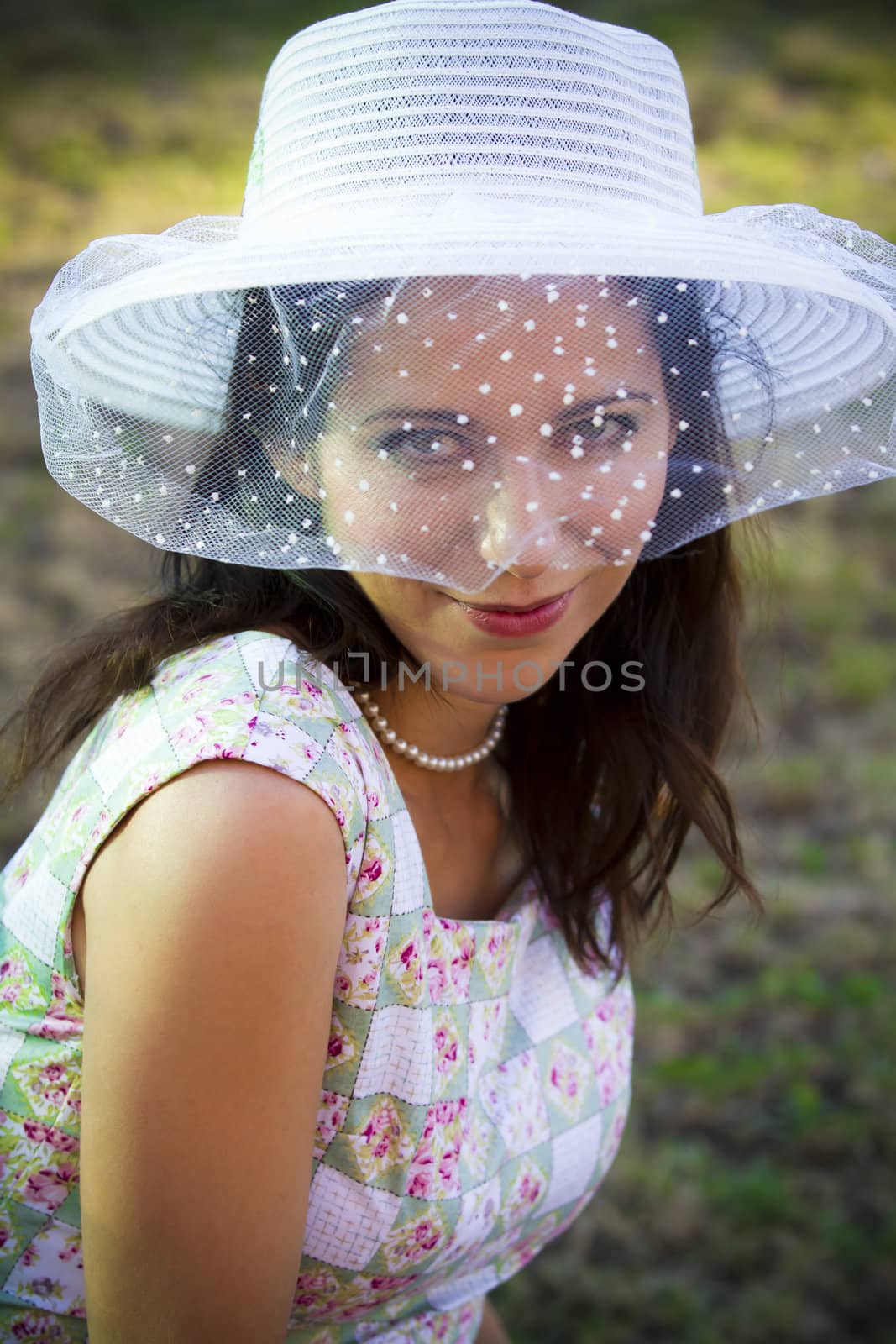 Sensual woman in the summer season with hat in a park