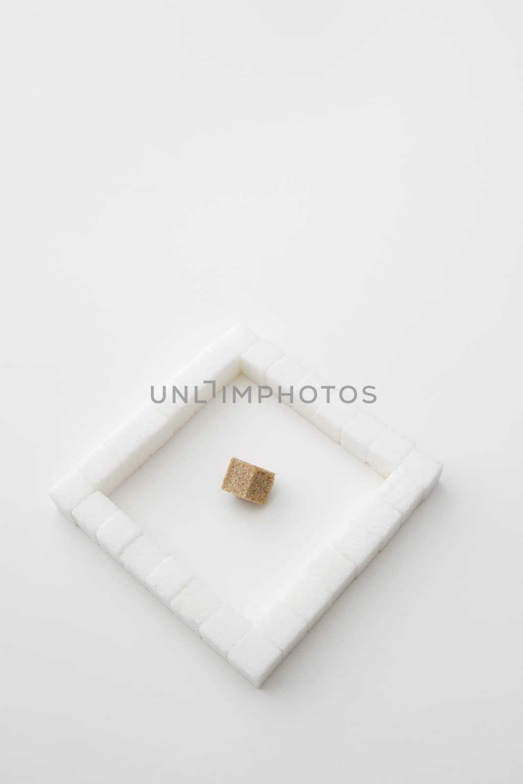 white sugar cube place in a square with on brown sugar square in the middle