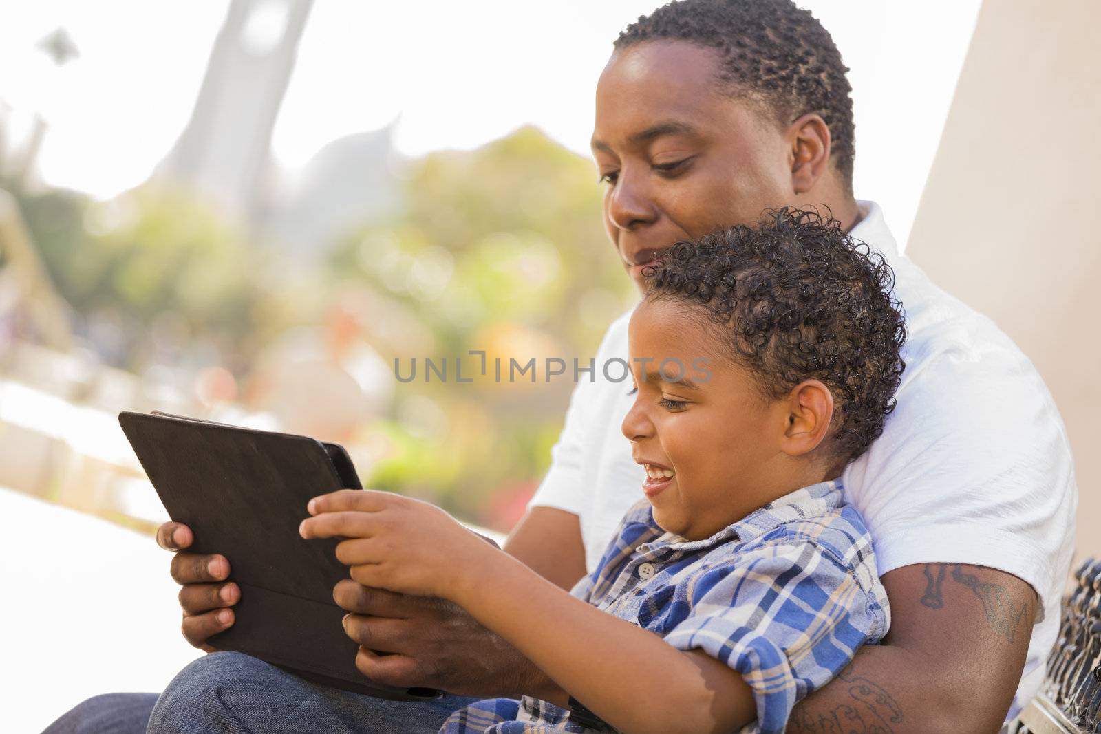 Mixed Race Father and Son Using Touch Pad Computer Tablet by Feverpitched