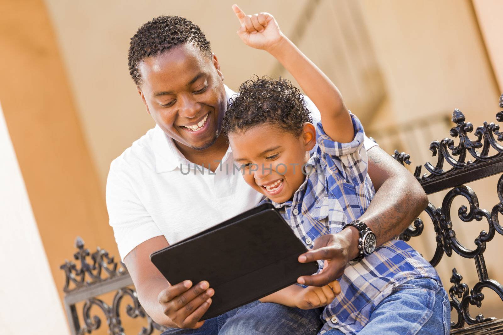 Mixed Race Father and Son Using Touch Pad Computer Tablet by Feverpitched