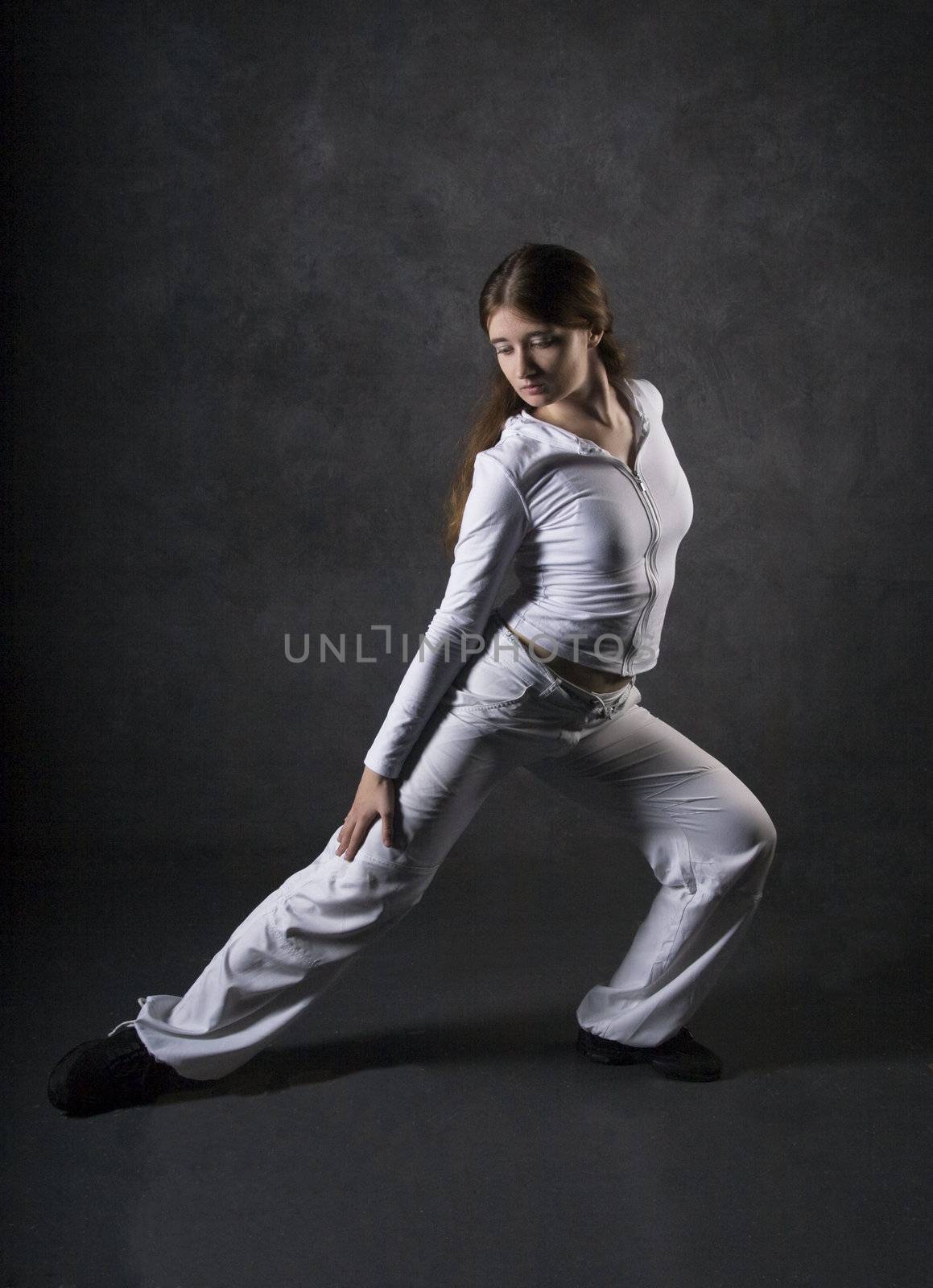 Young woman posing against gray concrete wall