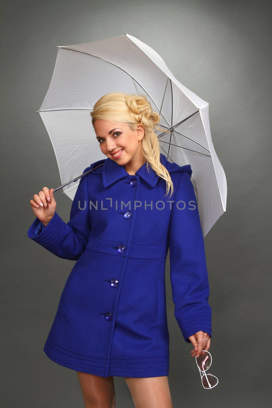 The beautiful blonde in a dark blue coat, with points in a hand and with a white umbrella