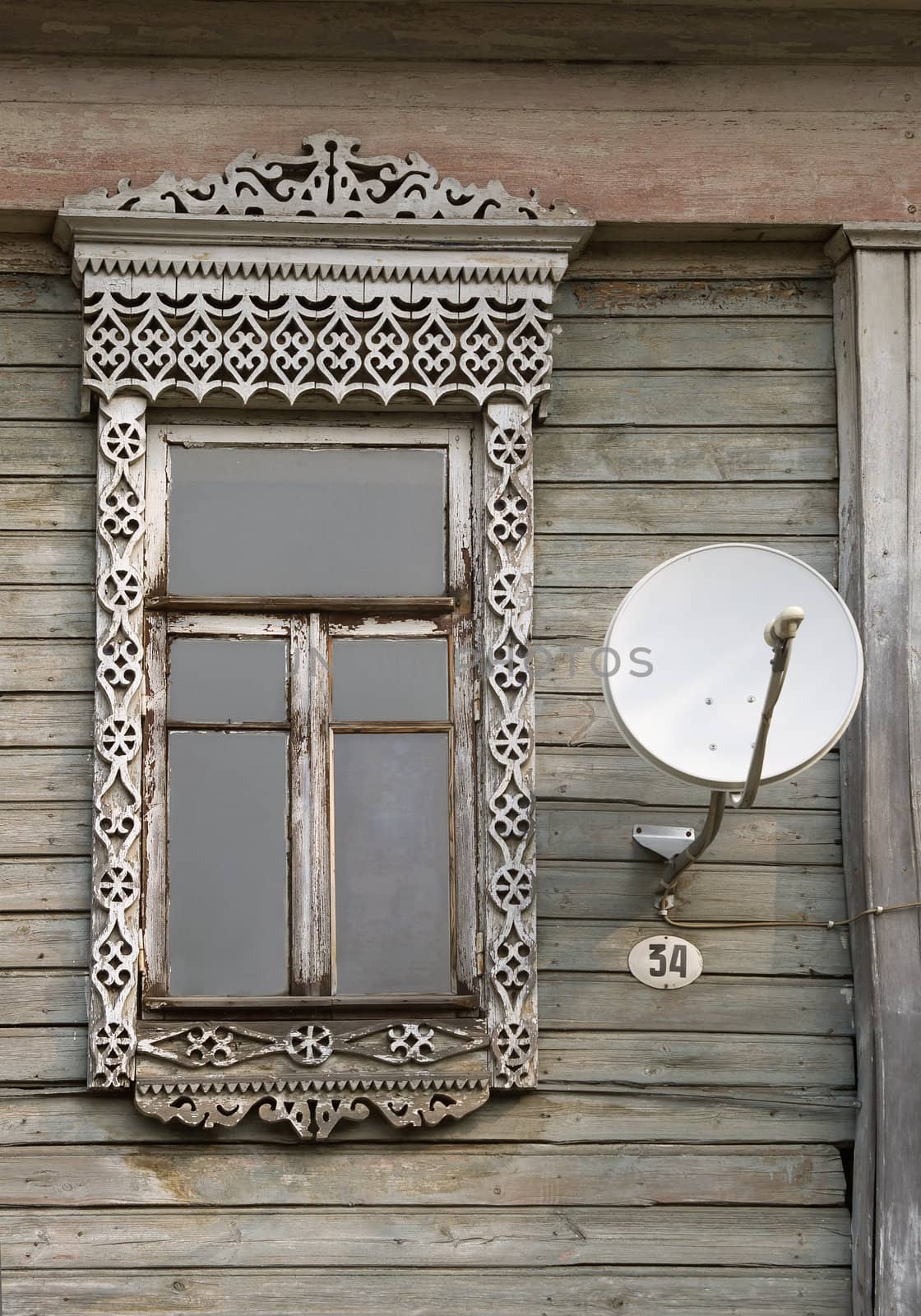 Window of an old russian house and satellite dish