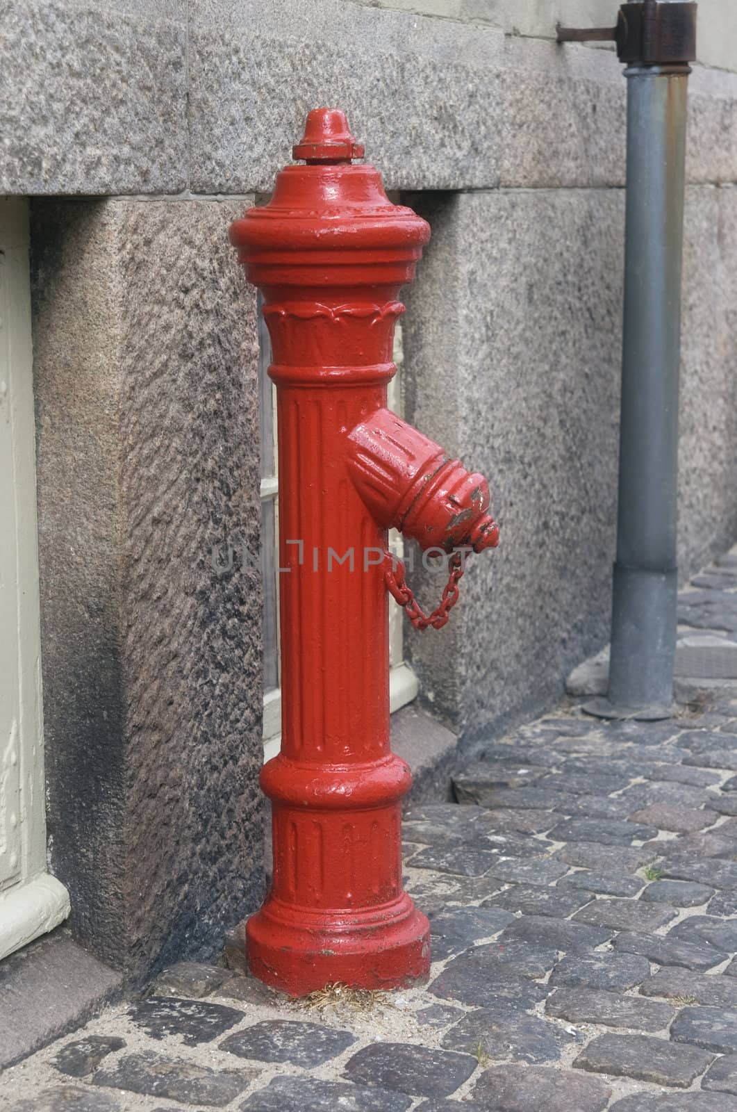 Red fire hydrant on a street in Denmark