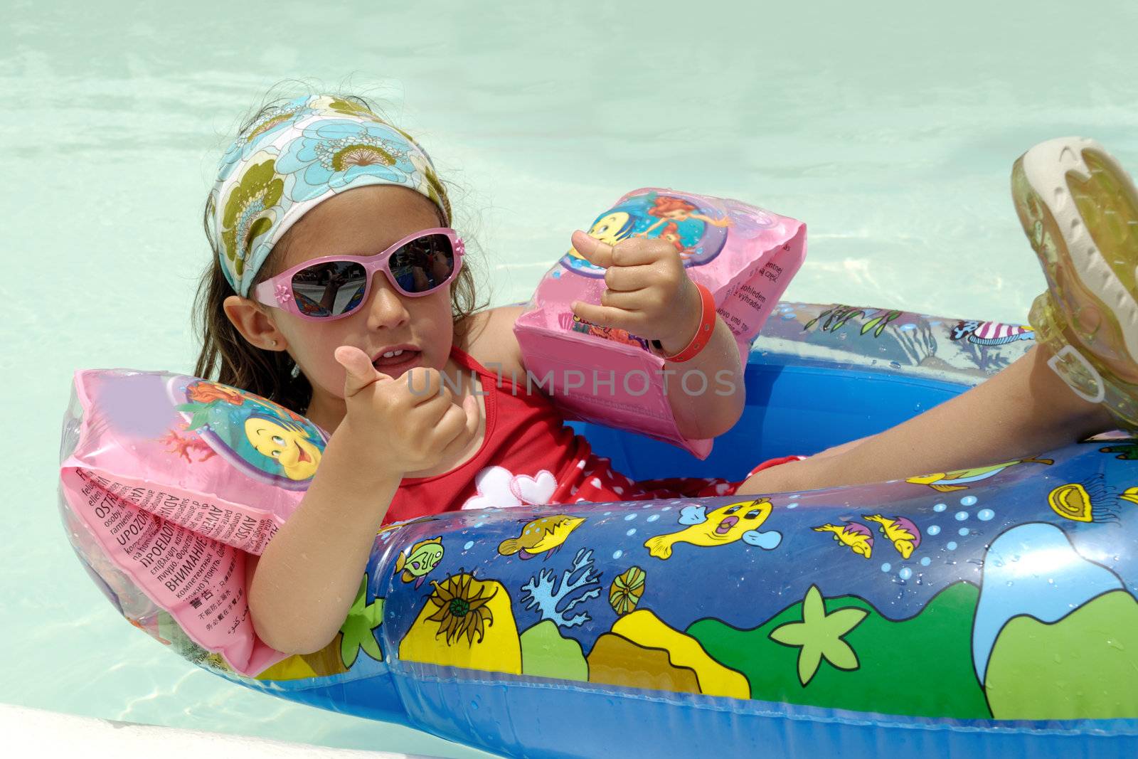 Child in pool relaxing by cfoto