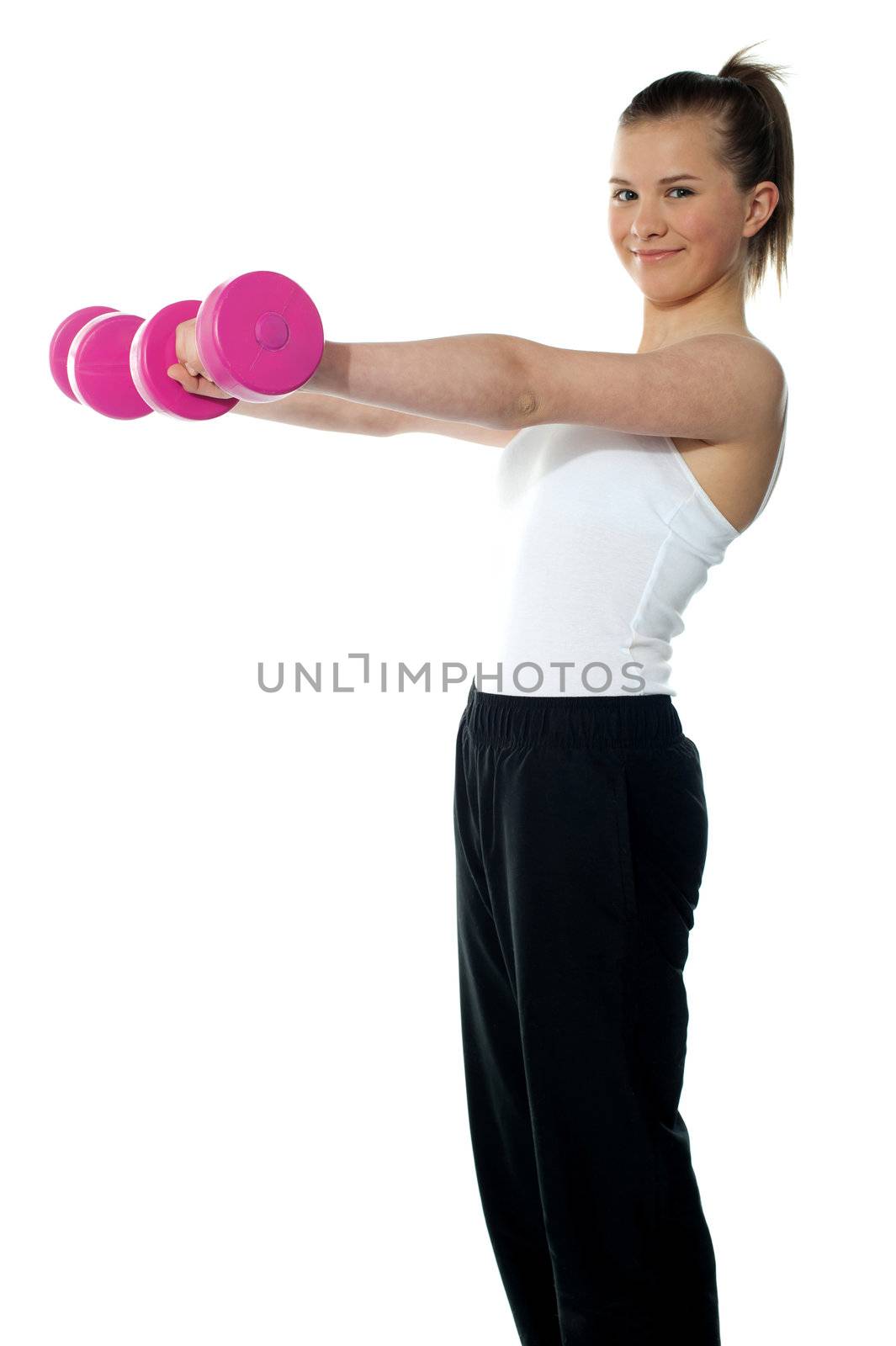 Pretty teenager working out with dumbbells. Shot in studio on white background