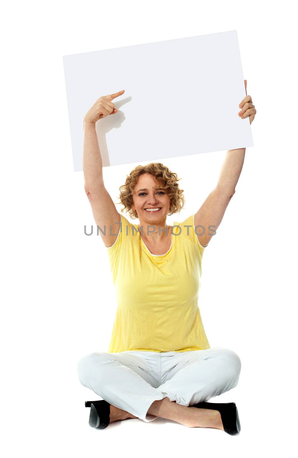 Senior woman pointing at blank ad board over her head
