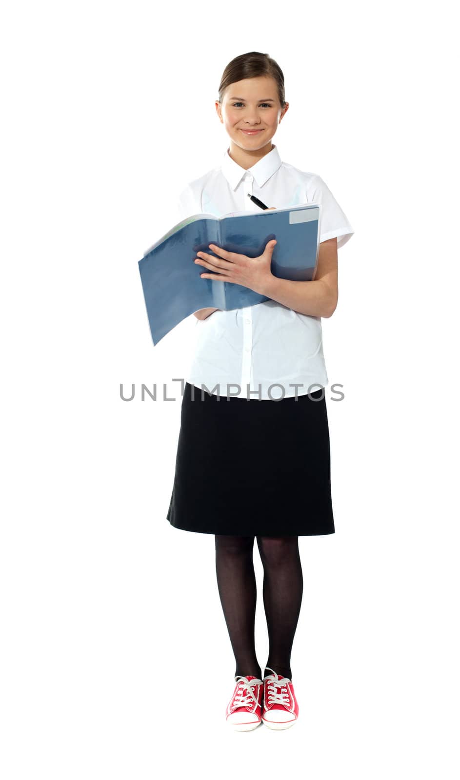 Full length portrait of smiling girl doing homework. All on white background