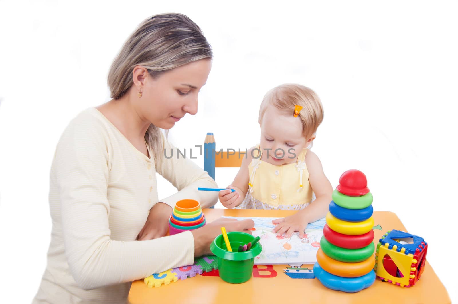 Baby girl drawing with her mother over white