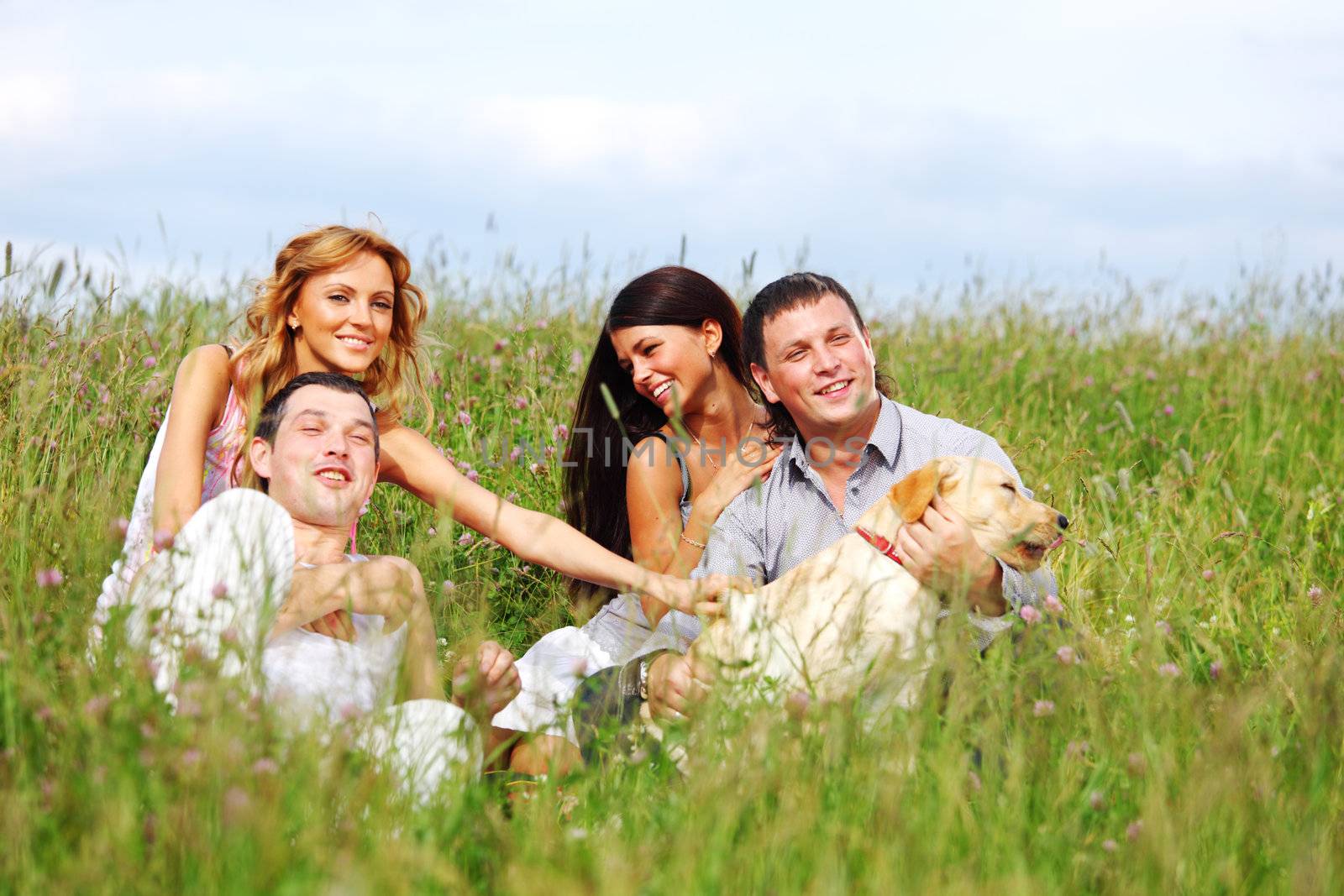 friends and dog in green grass field