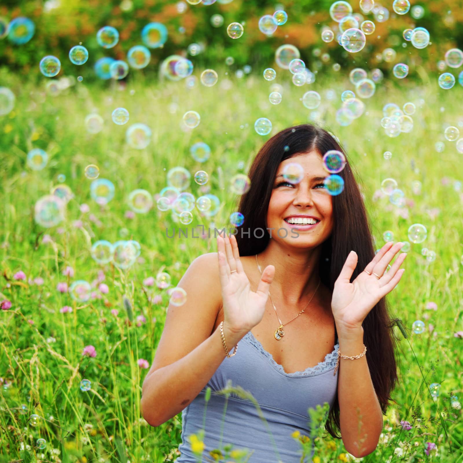 girlfriends on green grass field in soap bubbles