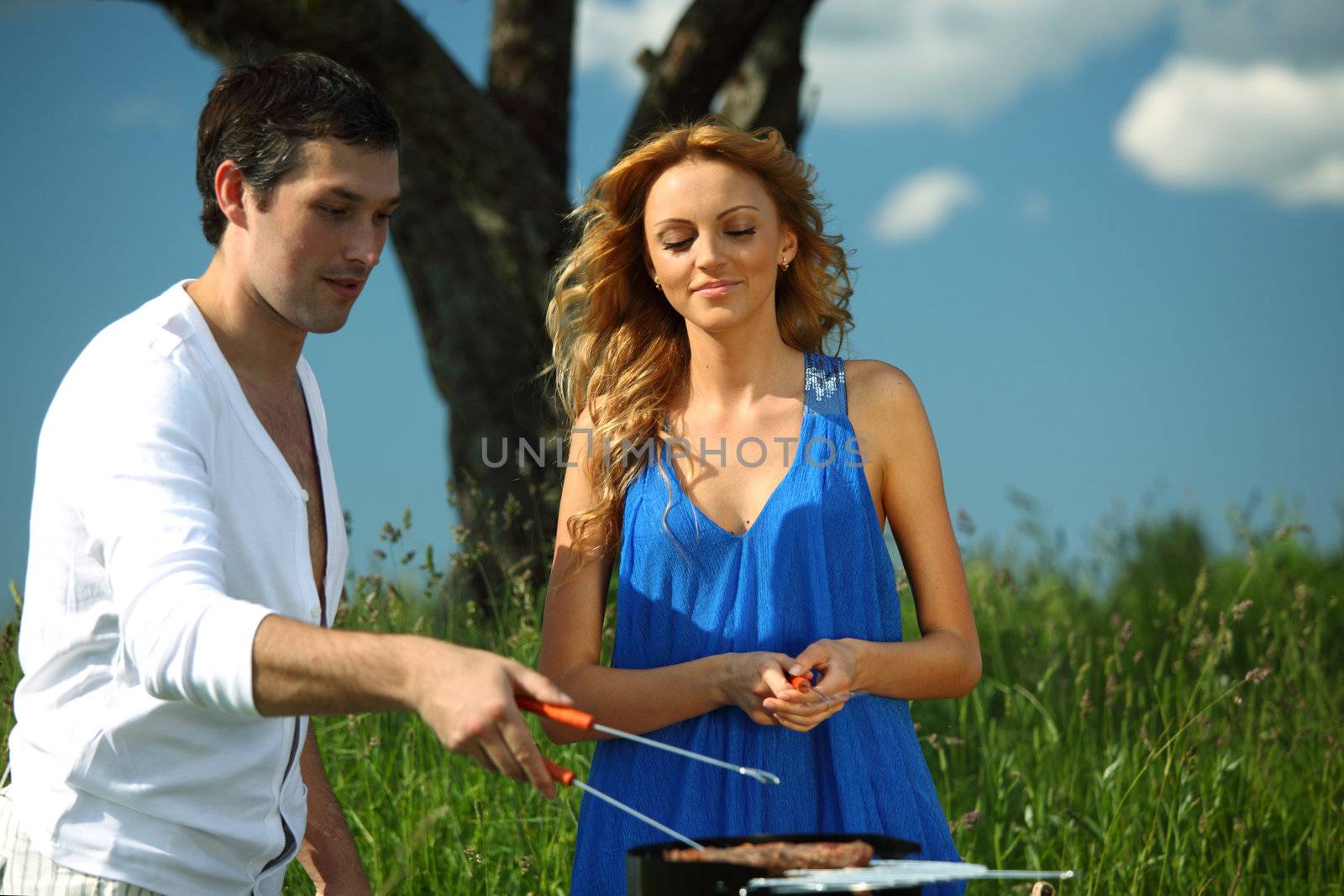 man and woman on picnic in green grass