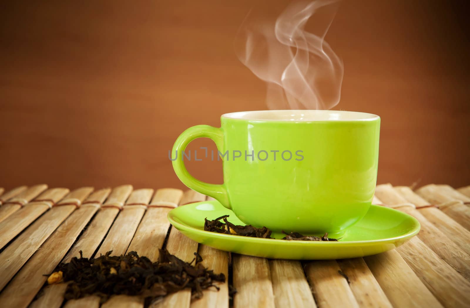 green cup of hot tea on wood background