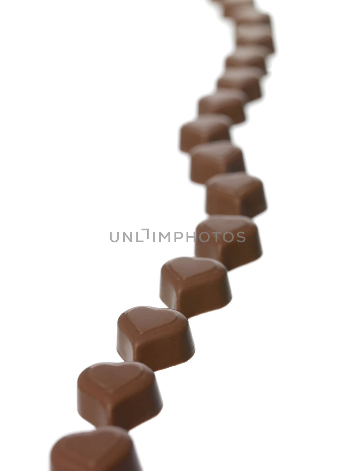 Heart shaped chocolate in a row on white background