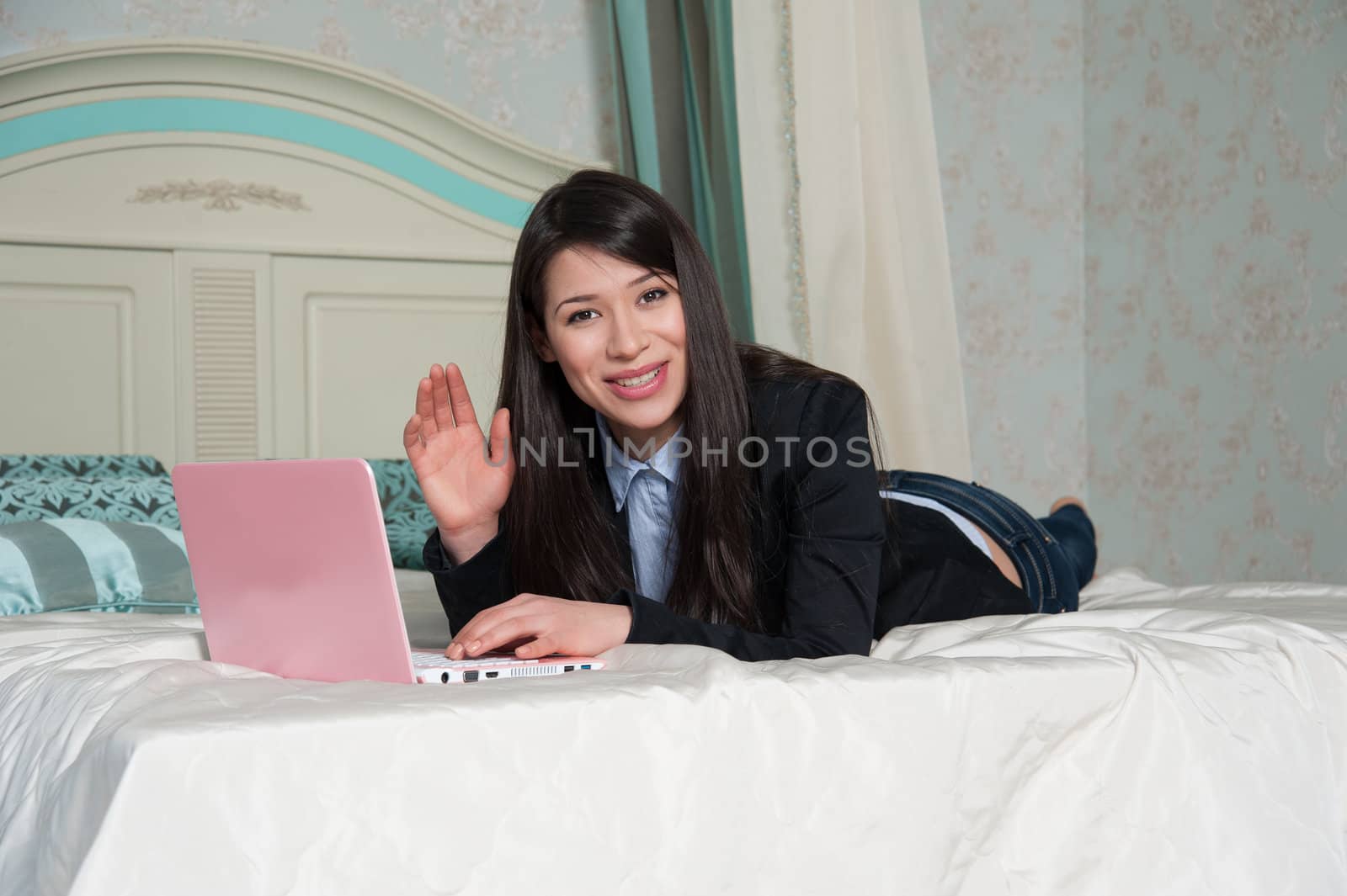  woman lying on the bed with laptop by raduga21