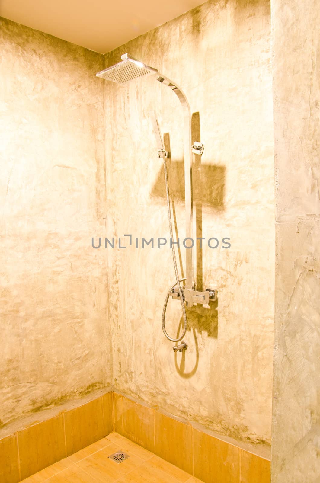 Shower in bathroom with polished concrete walls. Home interiors.