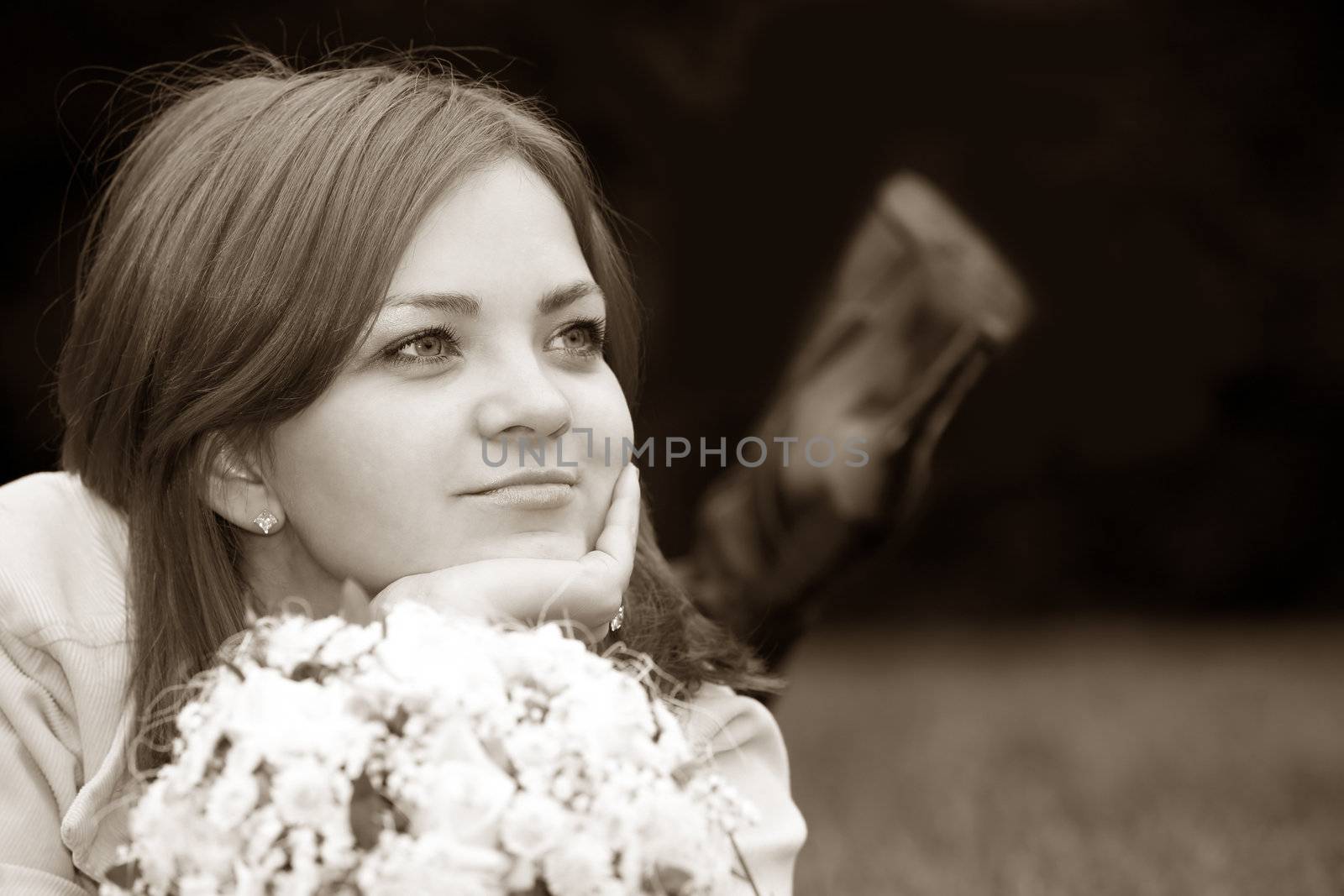 The nice girl with a bouquet in a grass