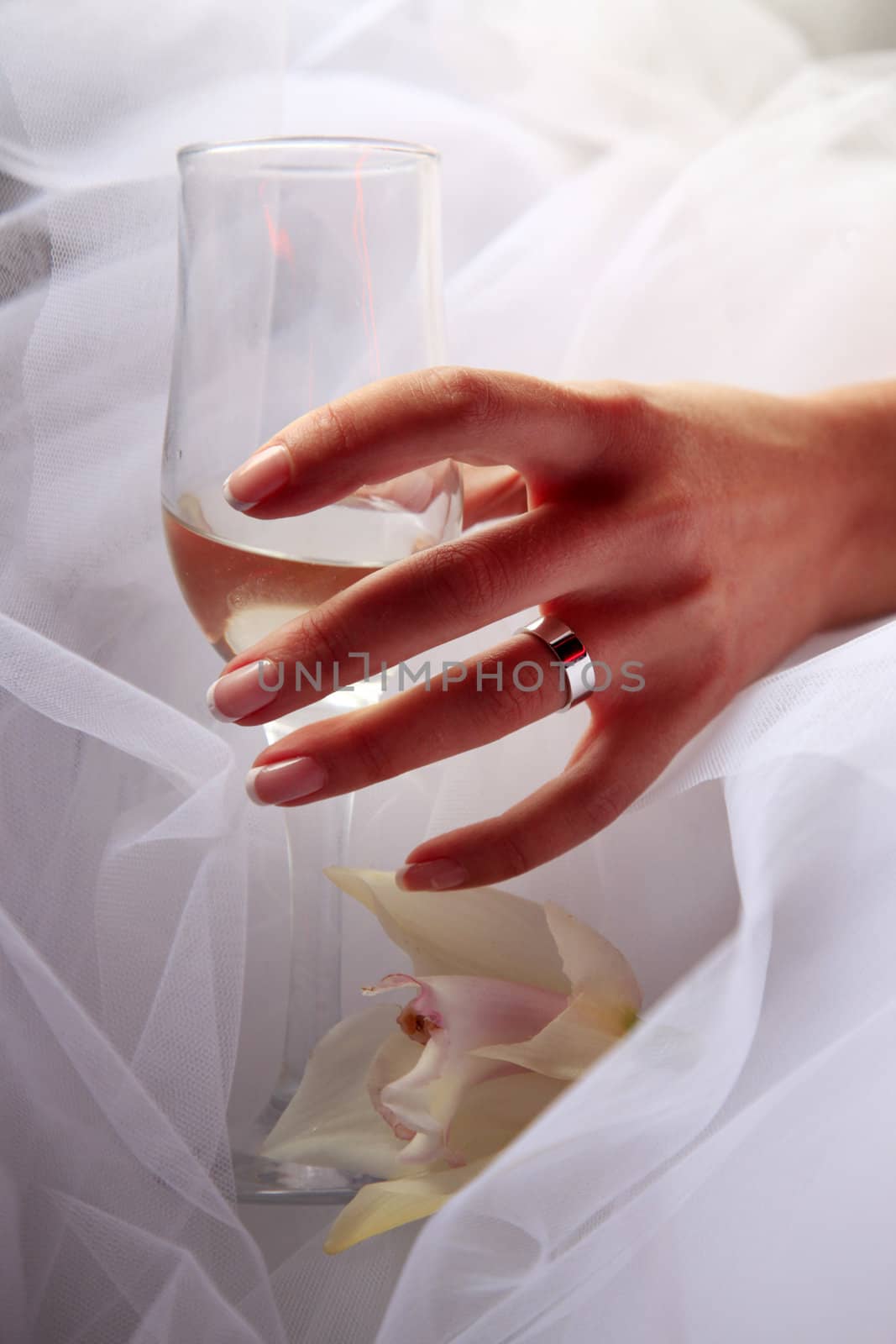 Glass of champagne in a hand of the bride