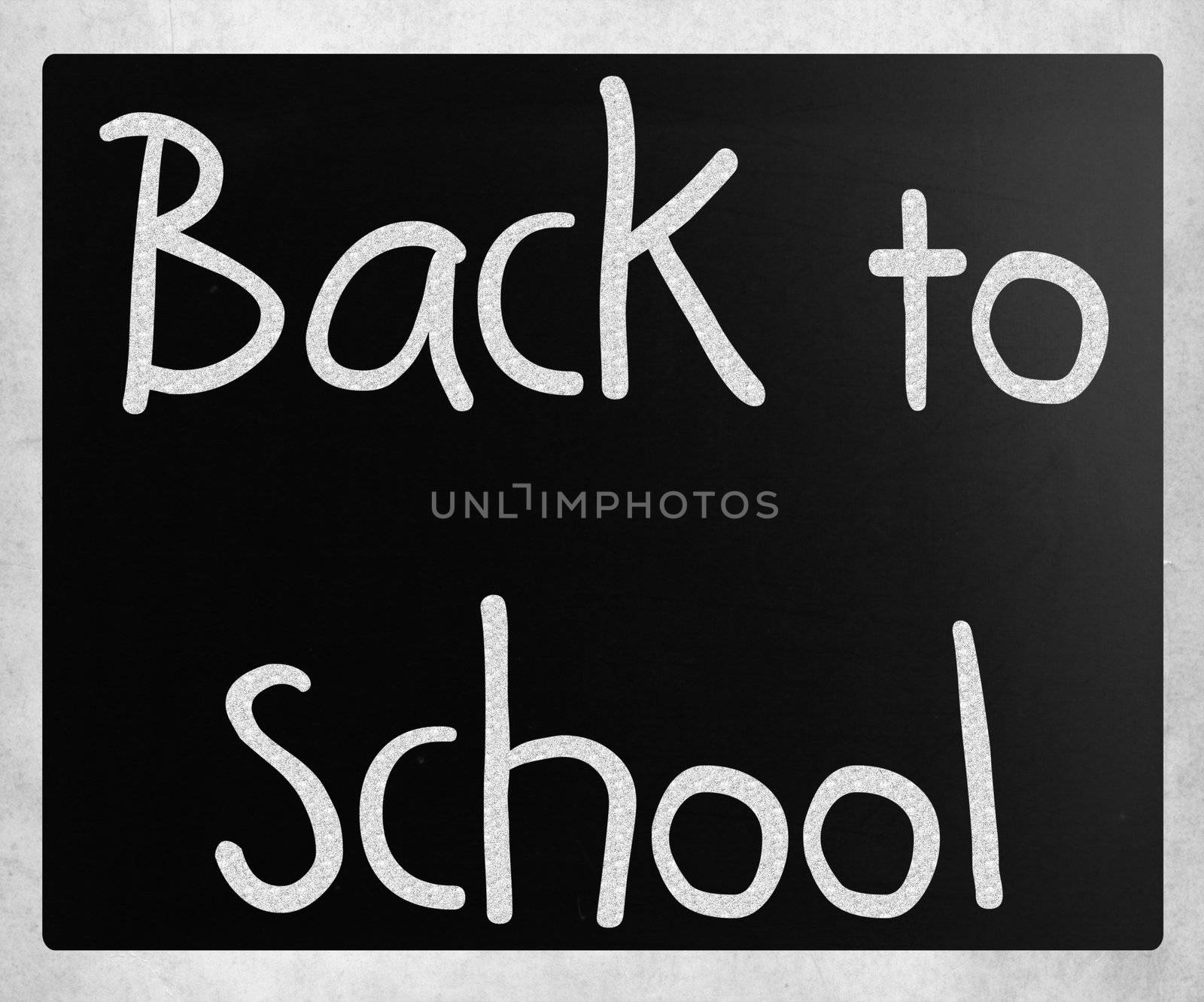 "Back to school" handwritten with white chalk on a blackboard