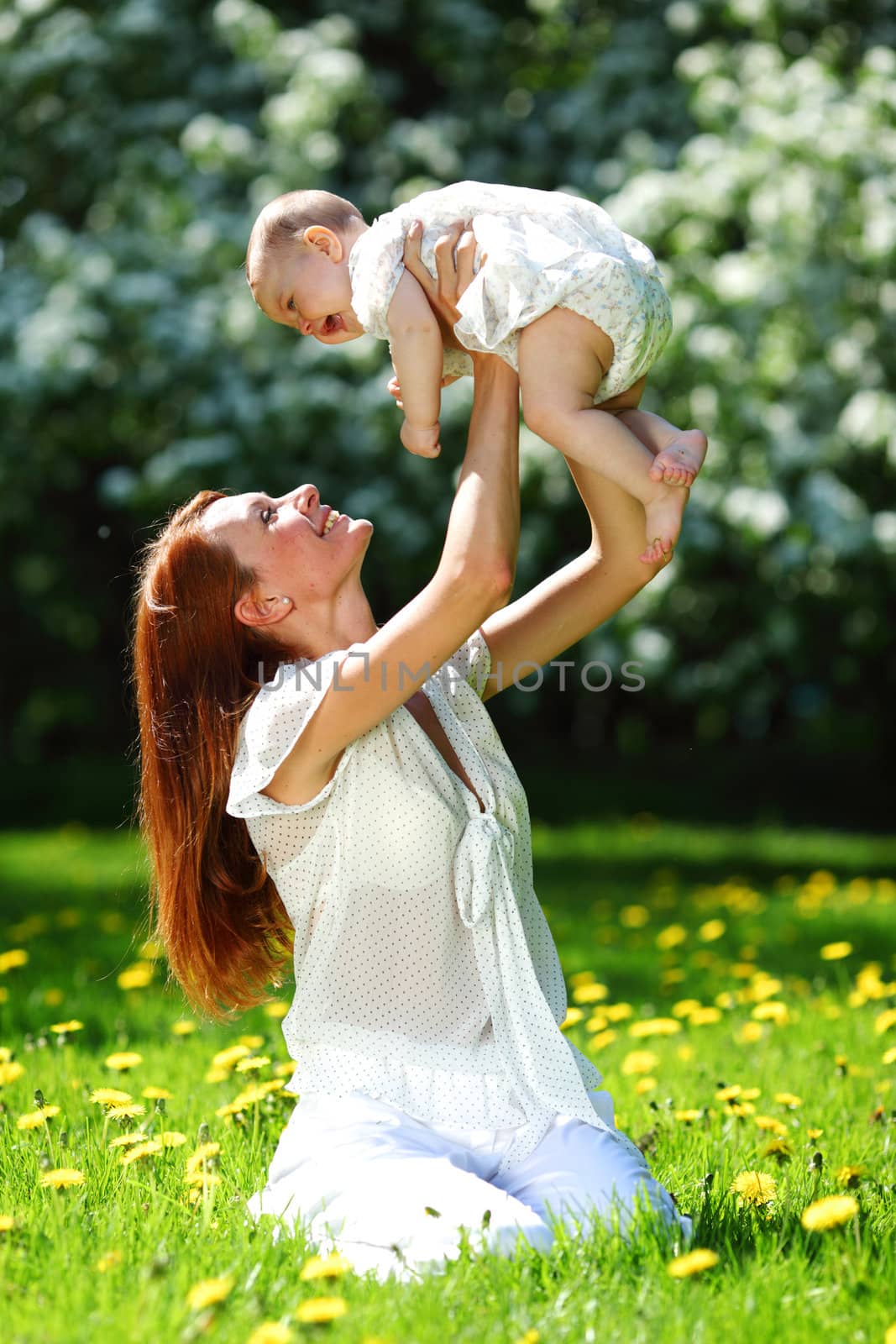 Happy mother and daughter on the green grass