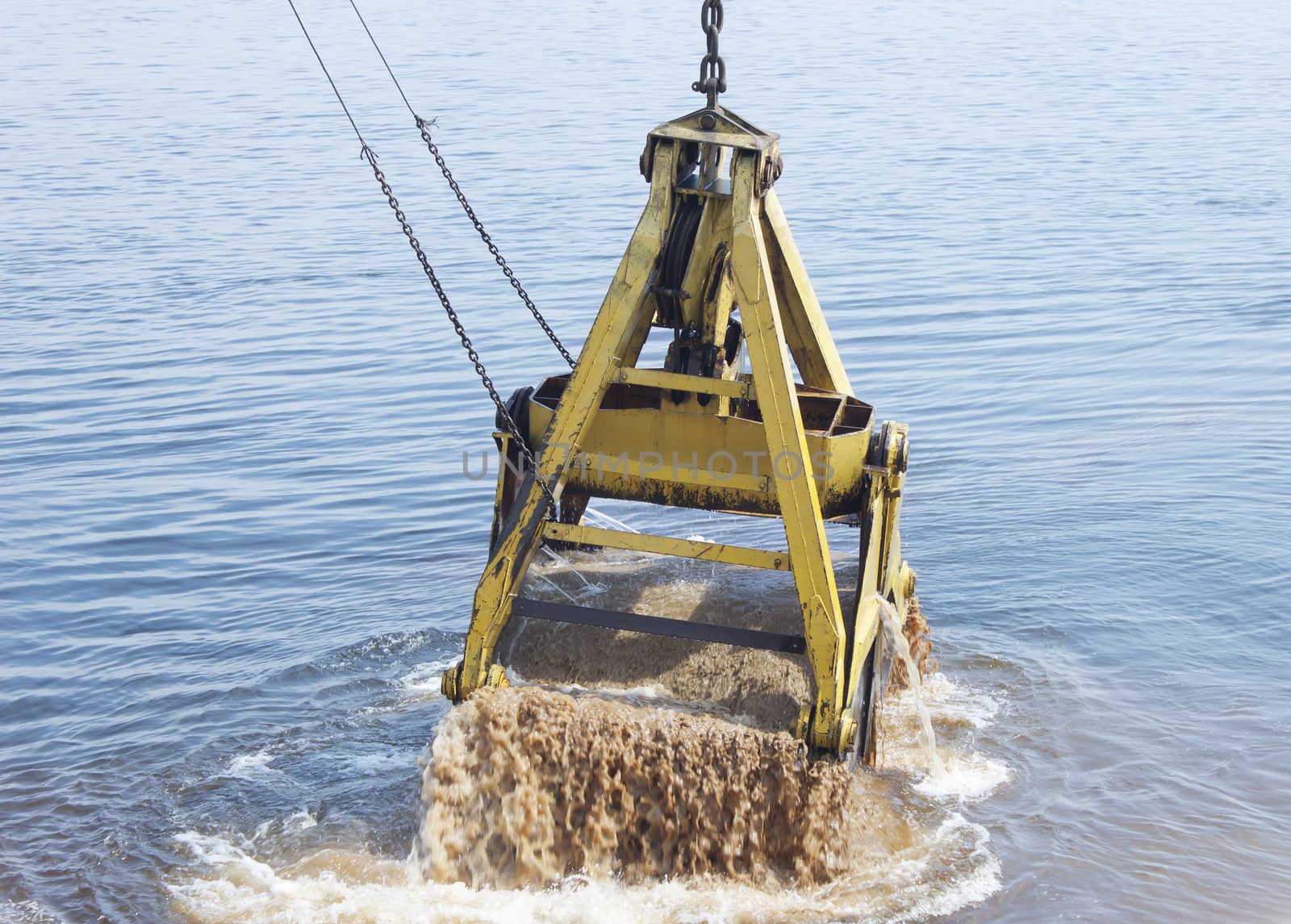 Crane scoops soil from the bottom of the river