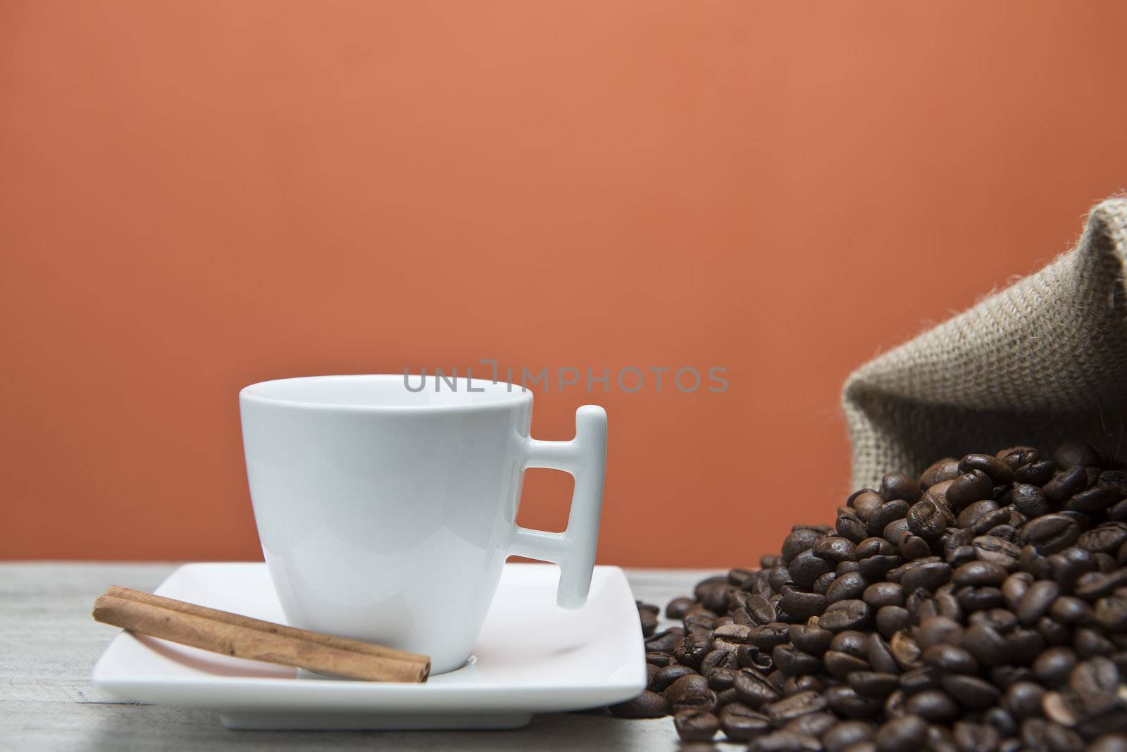 Cup of coffee and beans on an orange vintage background.