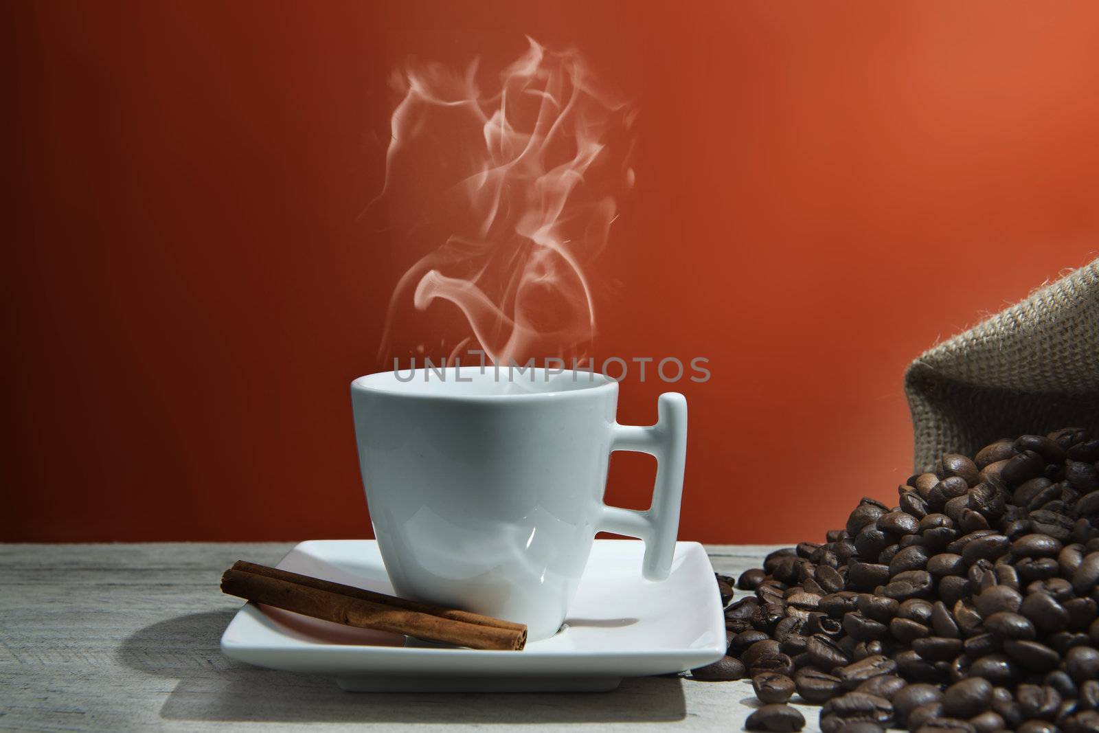 Cup of coffee and beans on an orange vintage background.