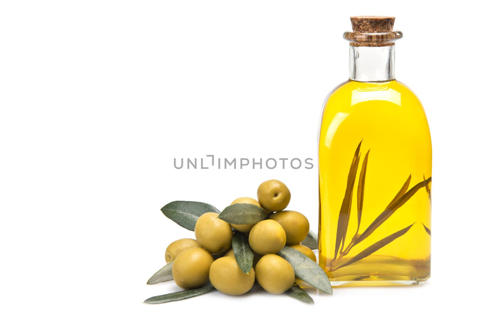 A jar with olive oil and some green olives isolated over a white background.