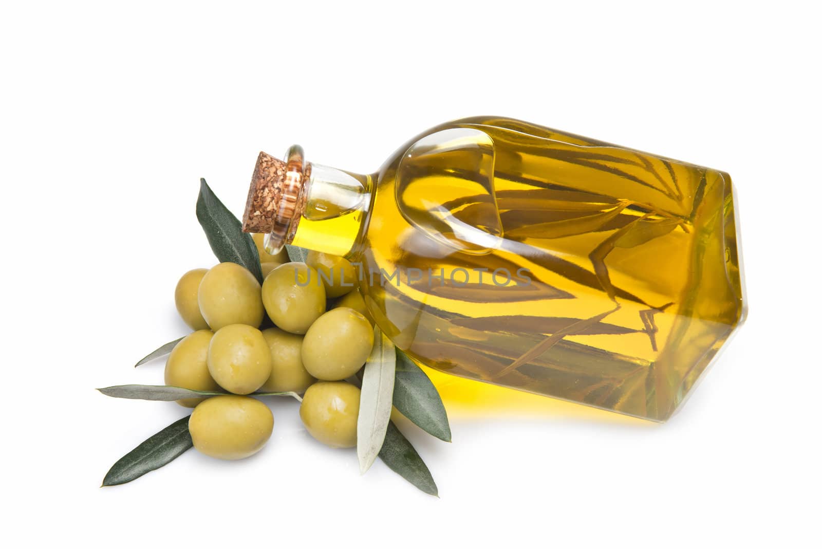 A jar with olive oil and some green olives isolated over a white background.