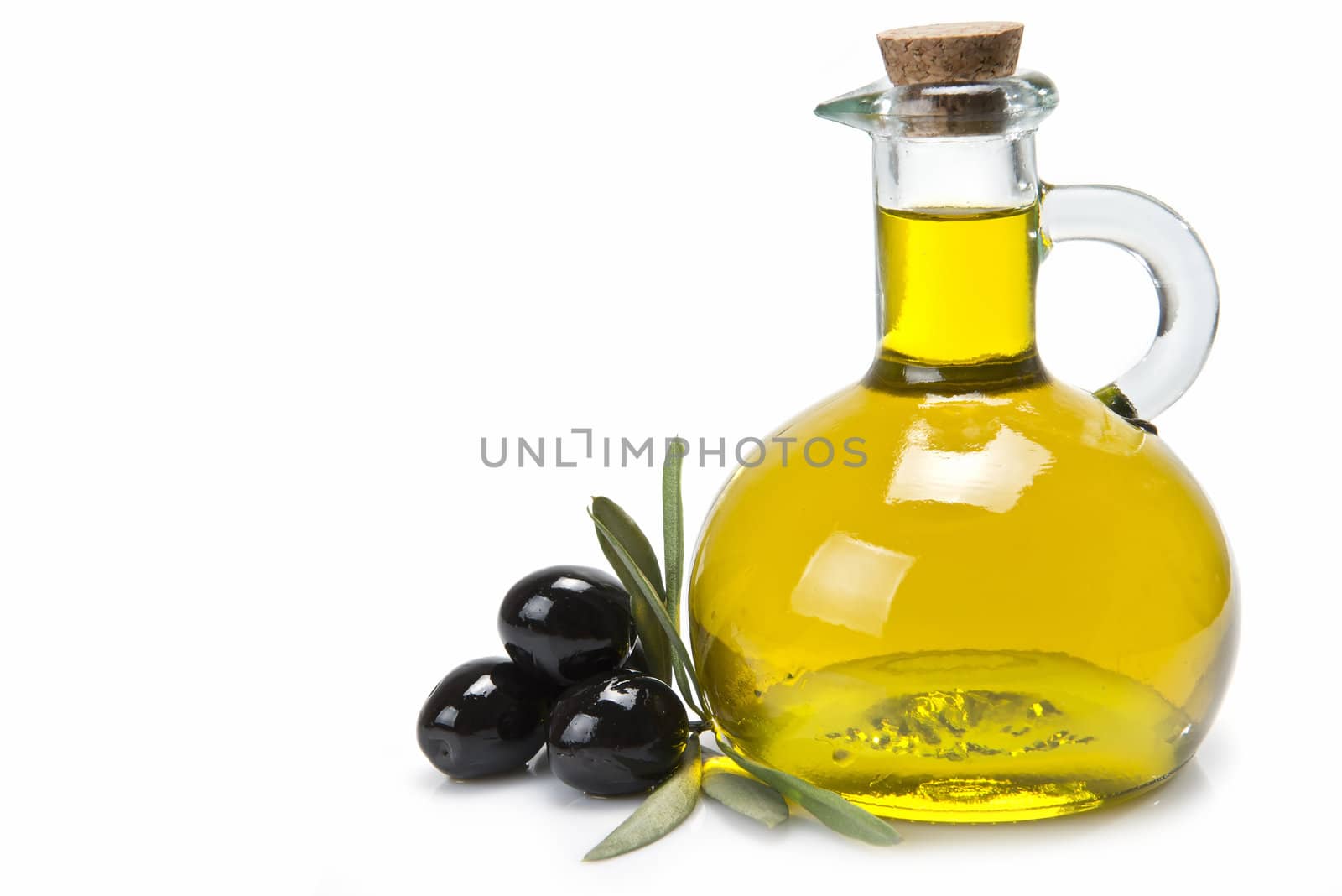 A jar with olive oil and some black olives isolated over a white background.
