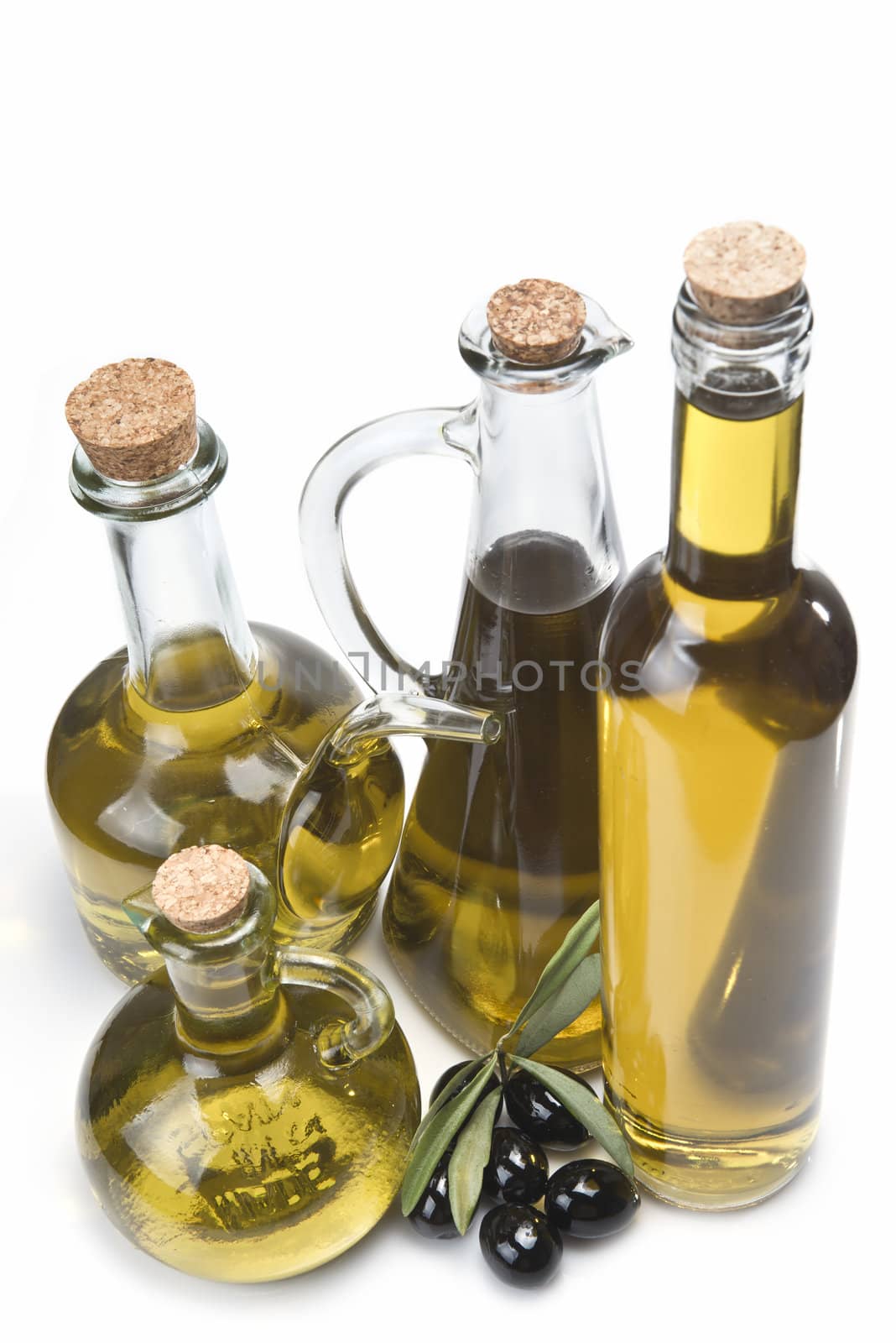 Set of olive oil bottles and black olives. by angelsimon