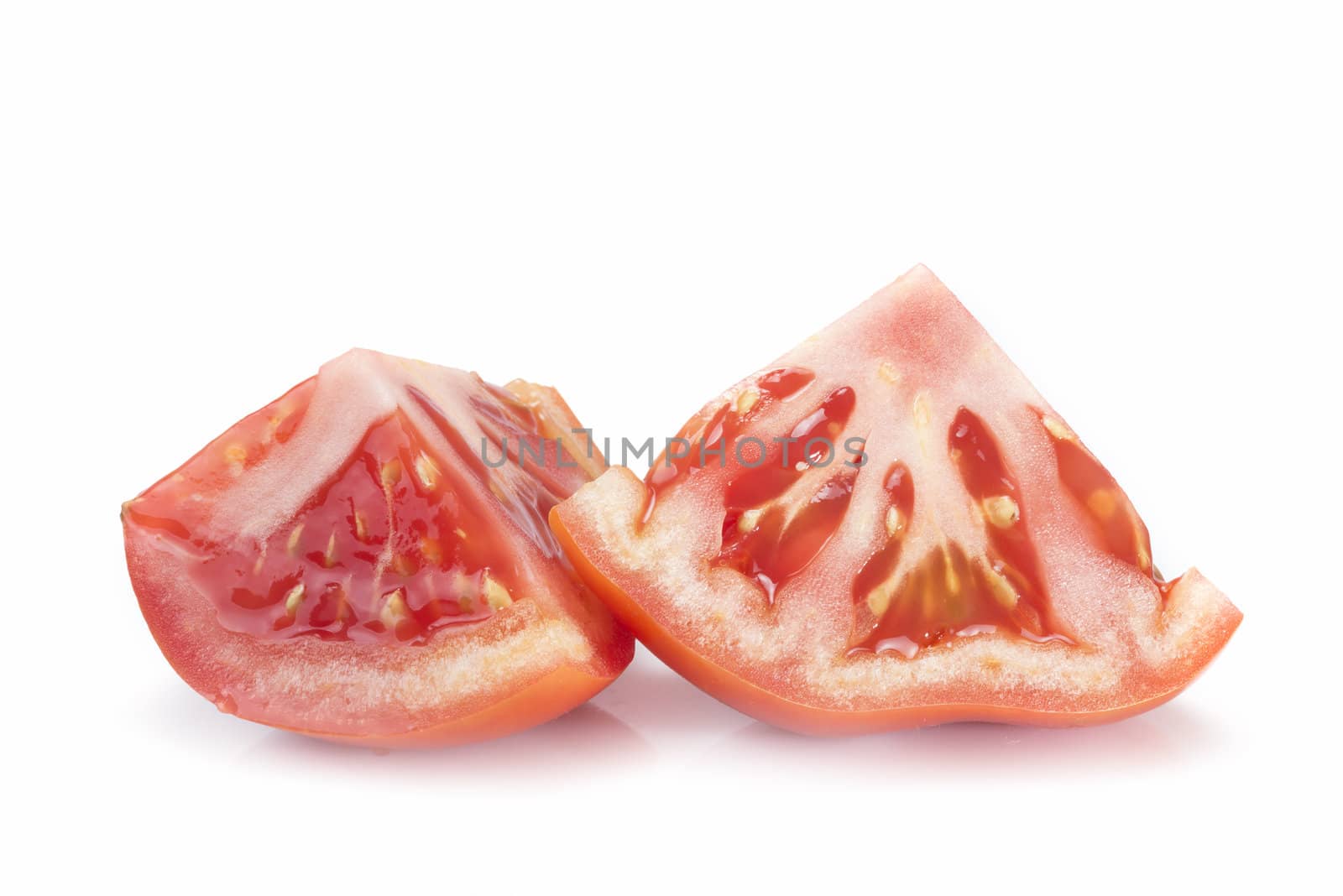 A fresh tomatoe cut isolated over a white background.