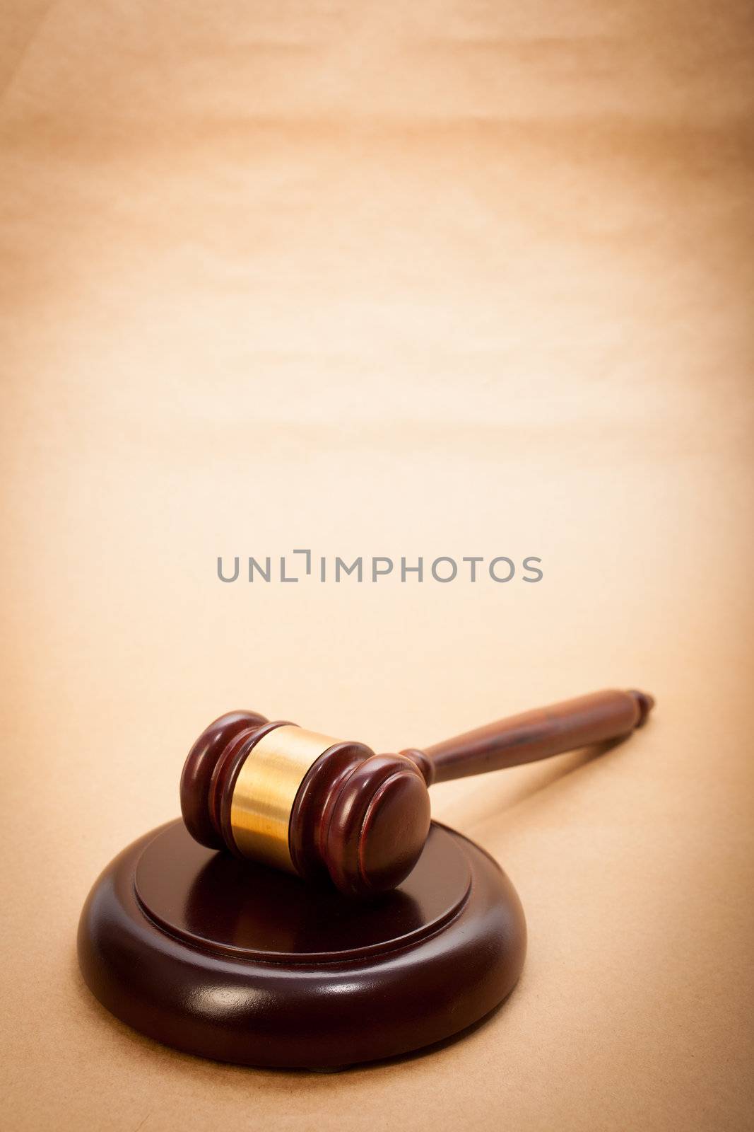 A wooden gavel and soundboard on a light brown background.