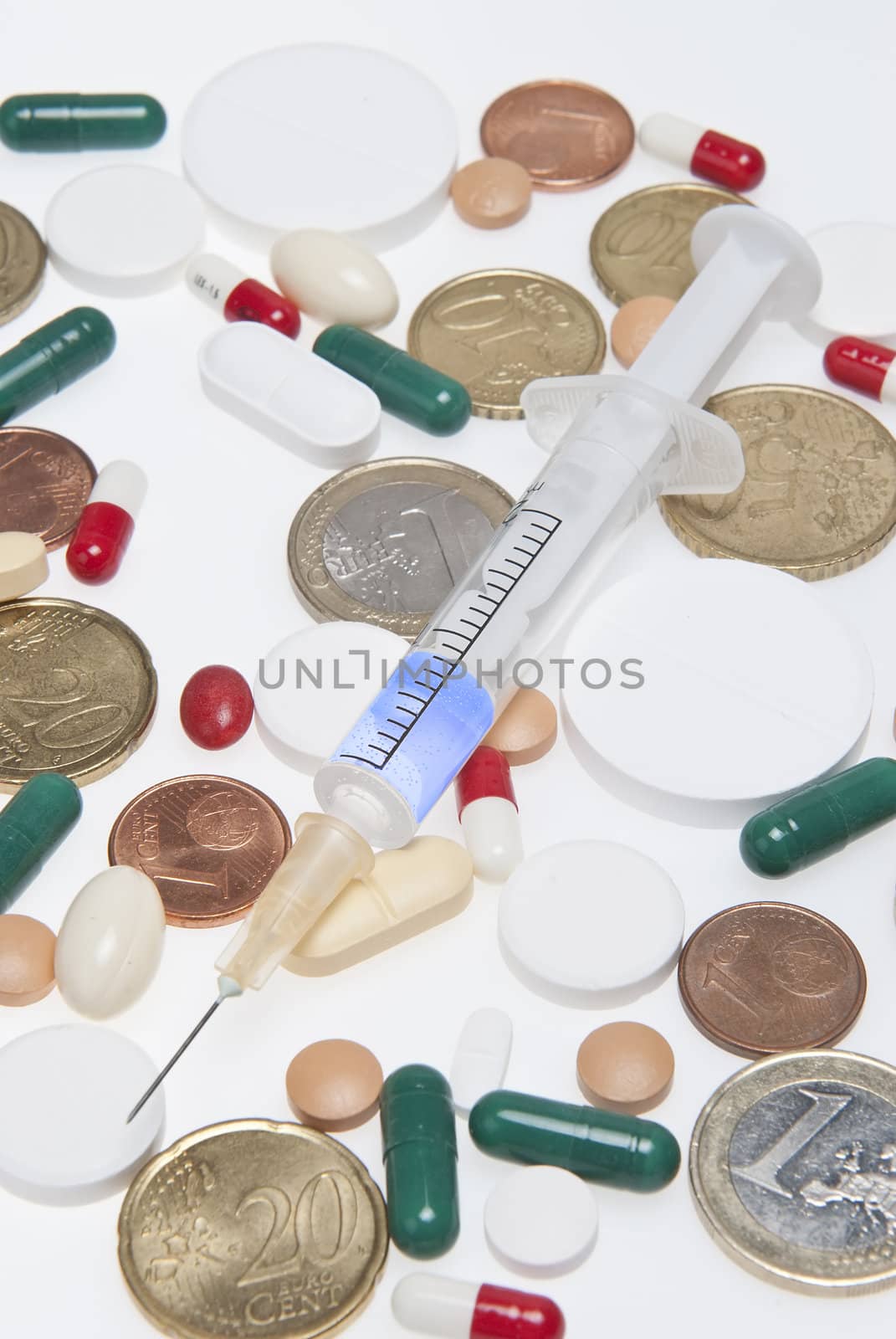 Some drugs and coins isolated over a white background.