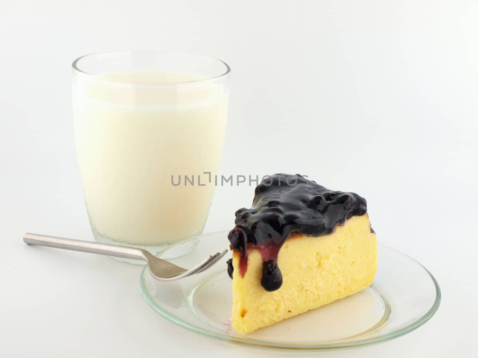 Milk with blueberry cheesecake on white background
