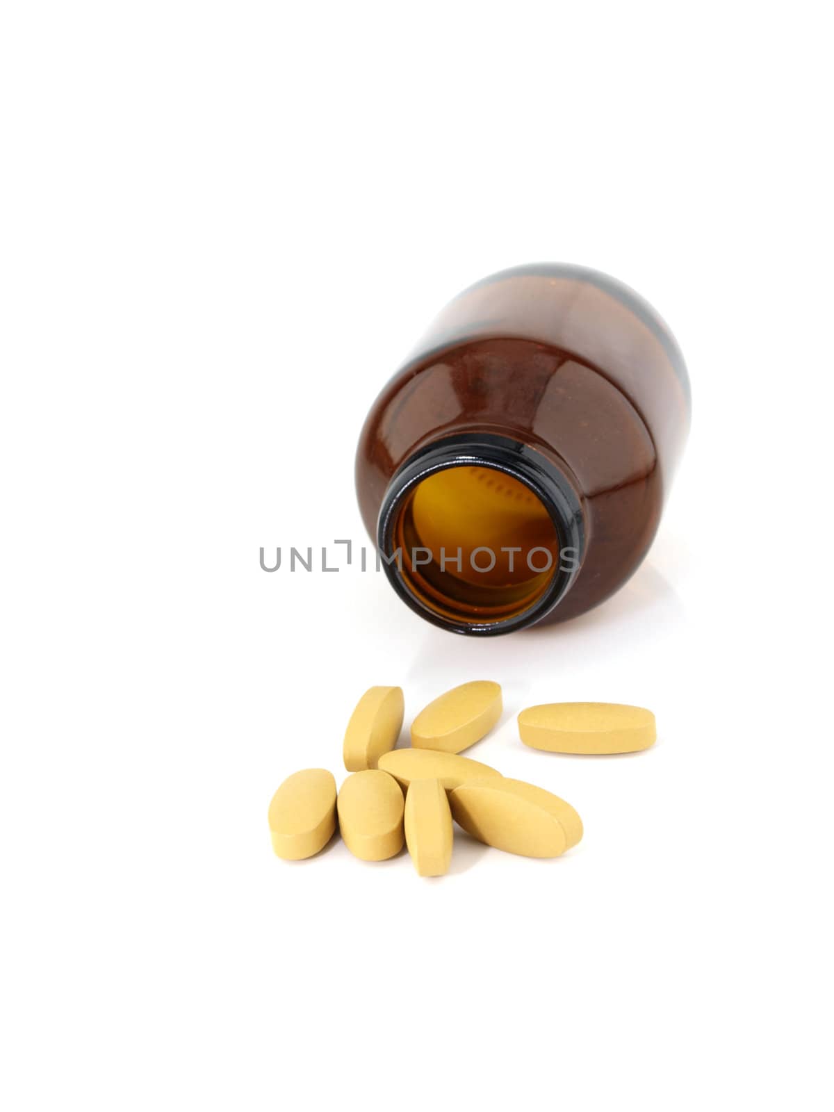 Vitamin C pills spilling from brown medicine bottle