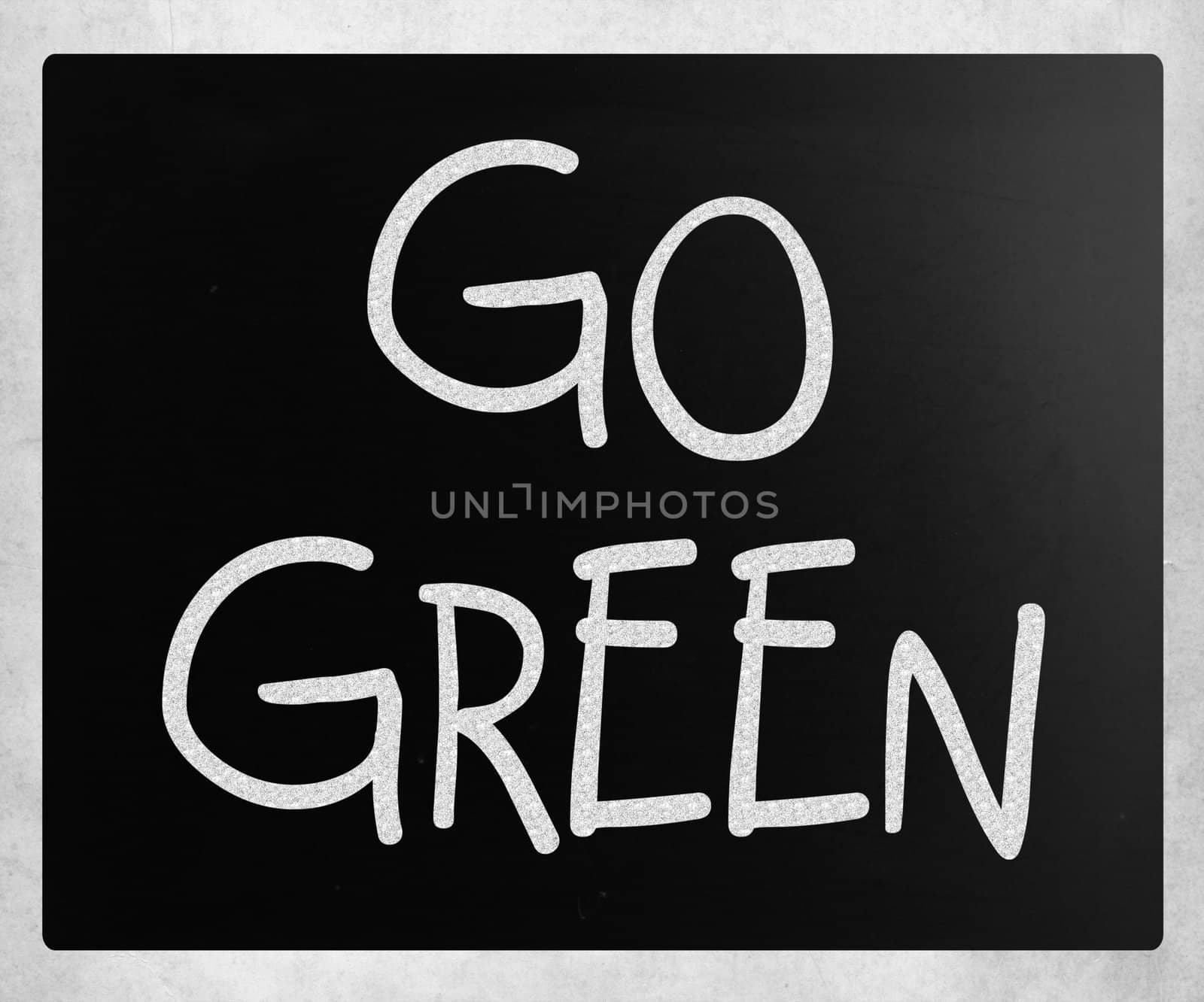 "Go green" handwritten with white chalk on a blackboard