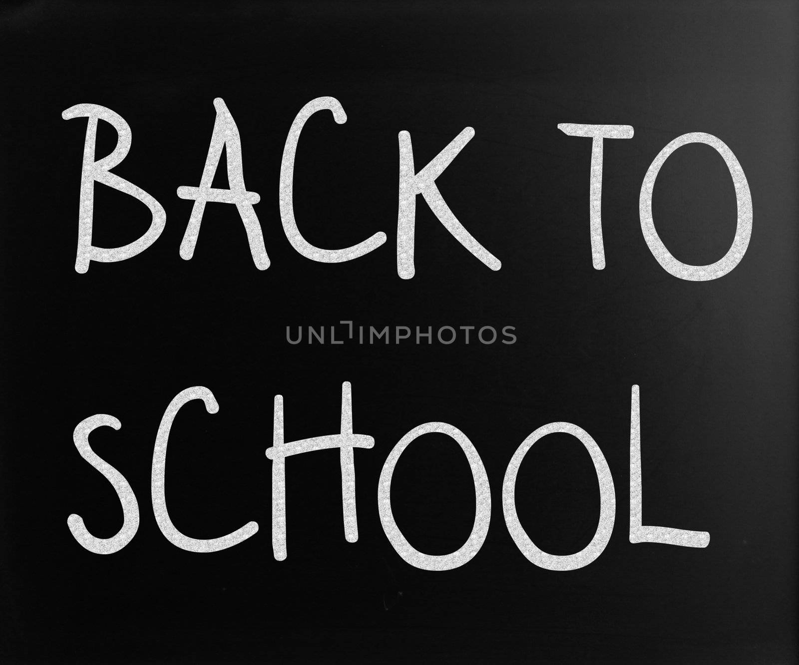 "Back to school" handwritten with white chalk on a blackboard
